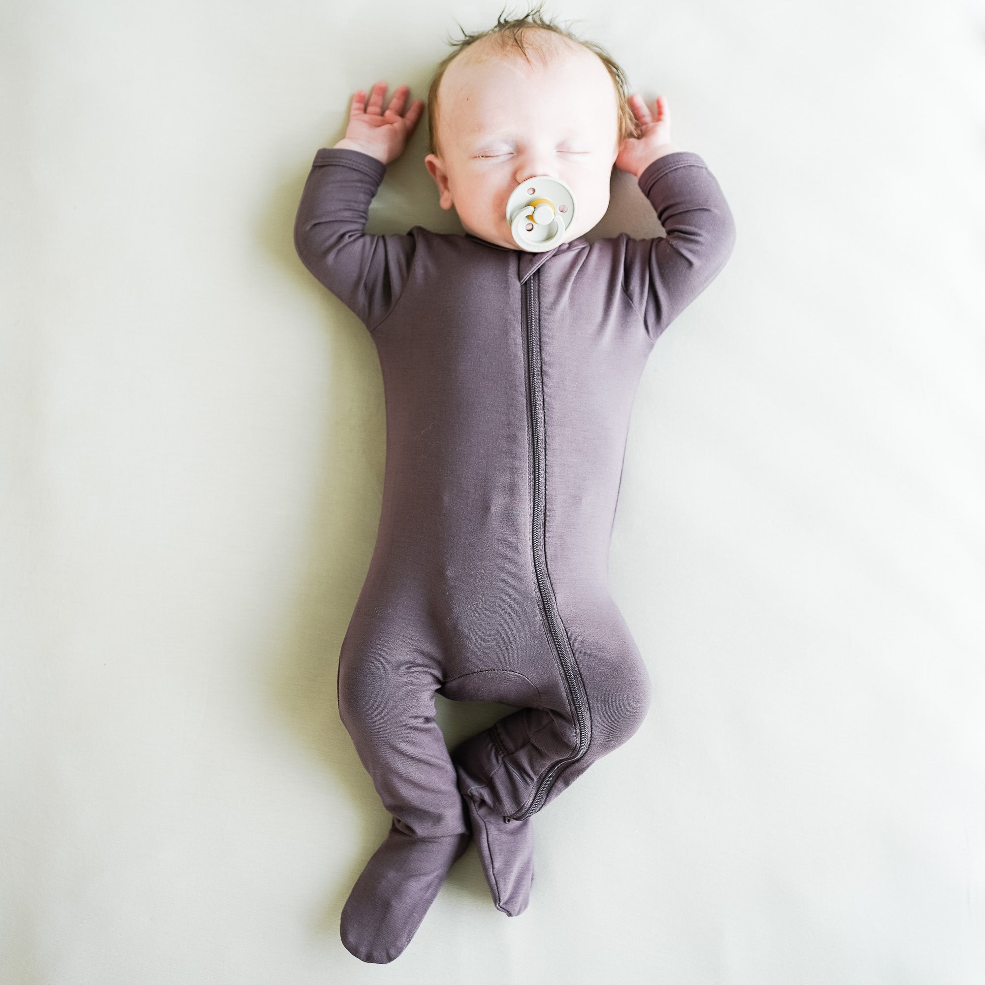baby sleeping with a pacifier in his mouth