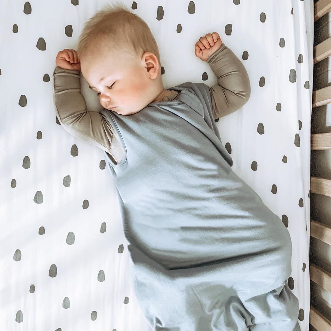 Baby sleeping in bamboo sleep bag and bodysuit