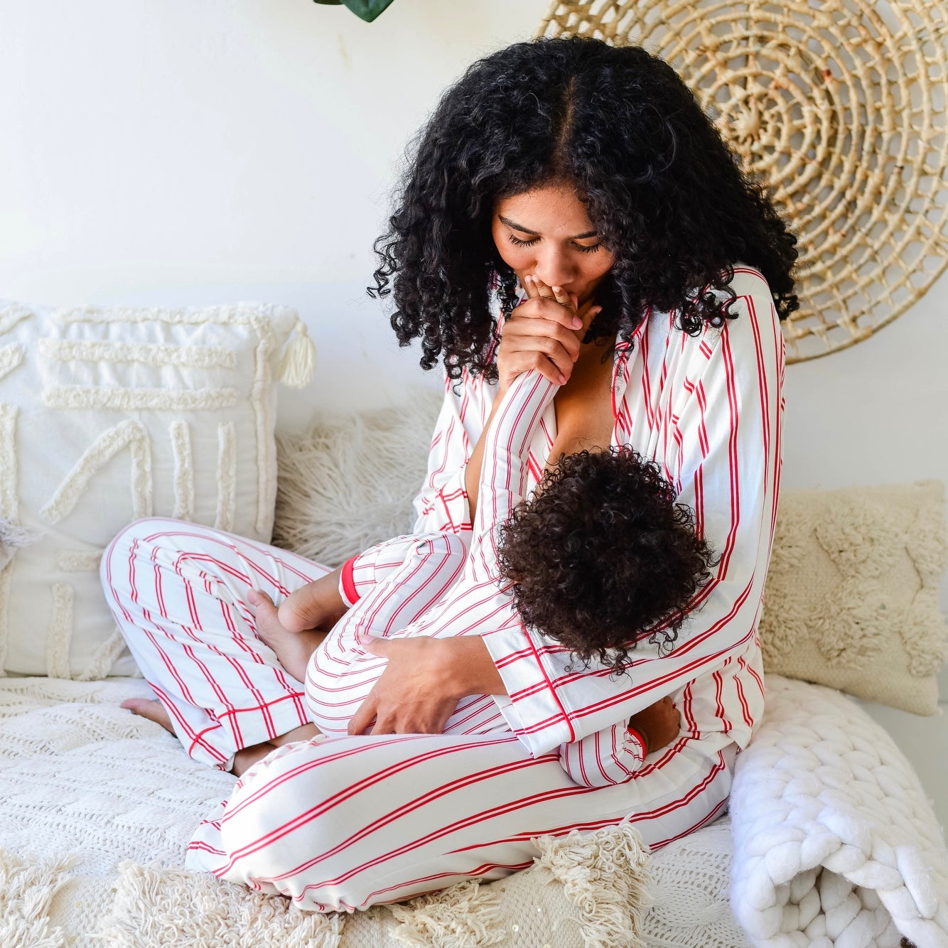 Mom feeding toddler in striped pajamas