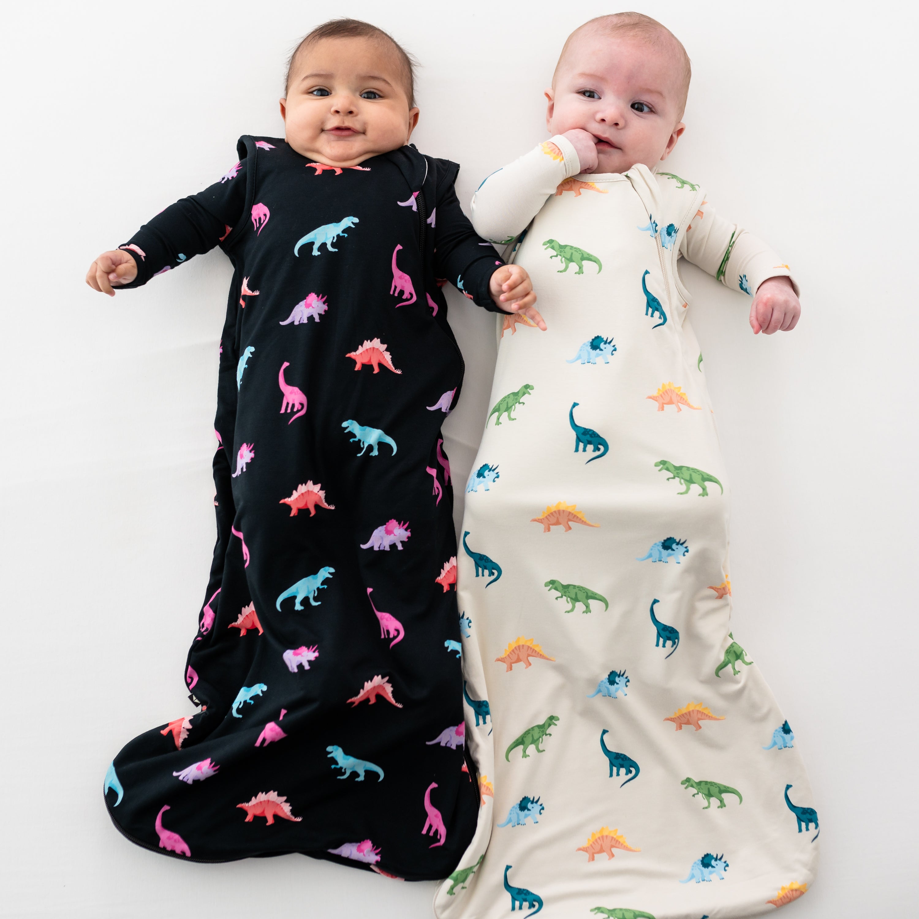 Two models shown in Kyte Baby 0.5 TOG Sleep Bags in Ecru and Midnight Roar