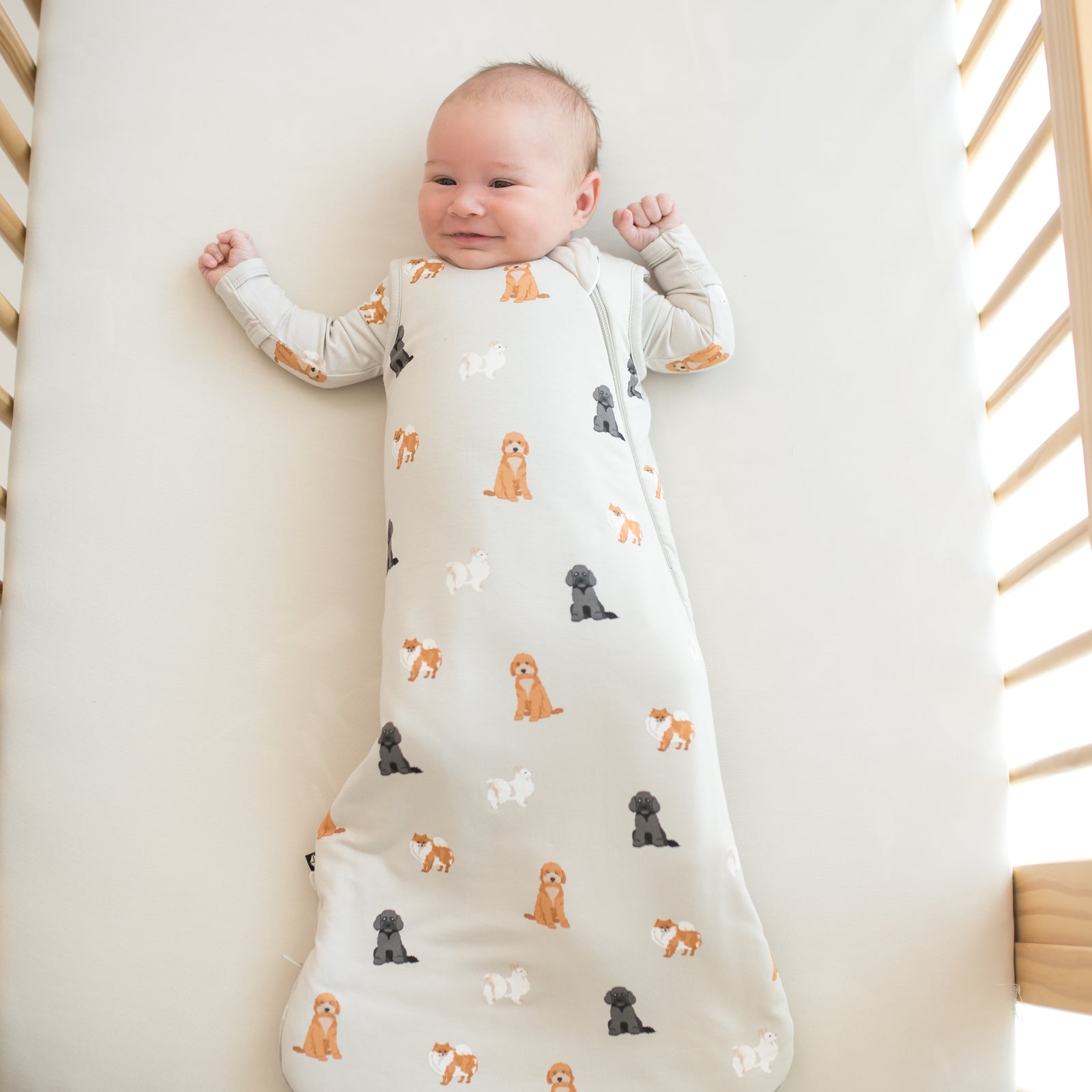 Smiling baby laying in crib wearing Sleep Bag in Fluffy Dog 1.0
