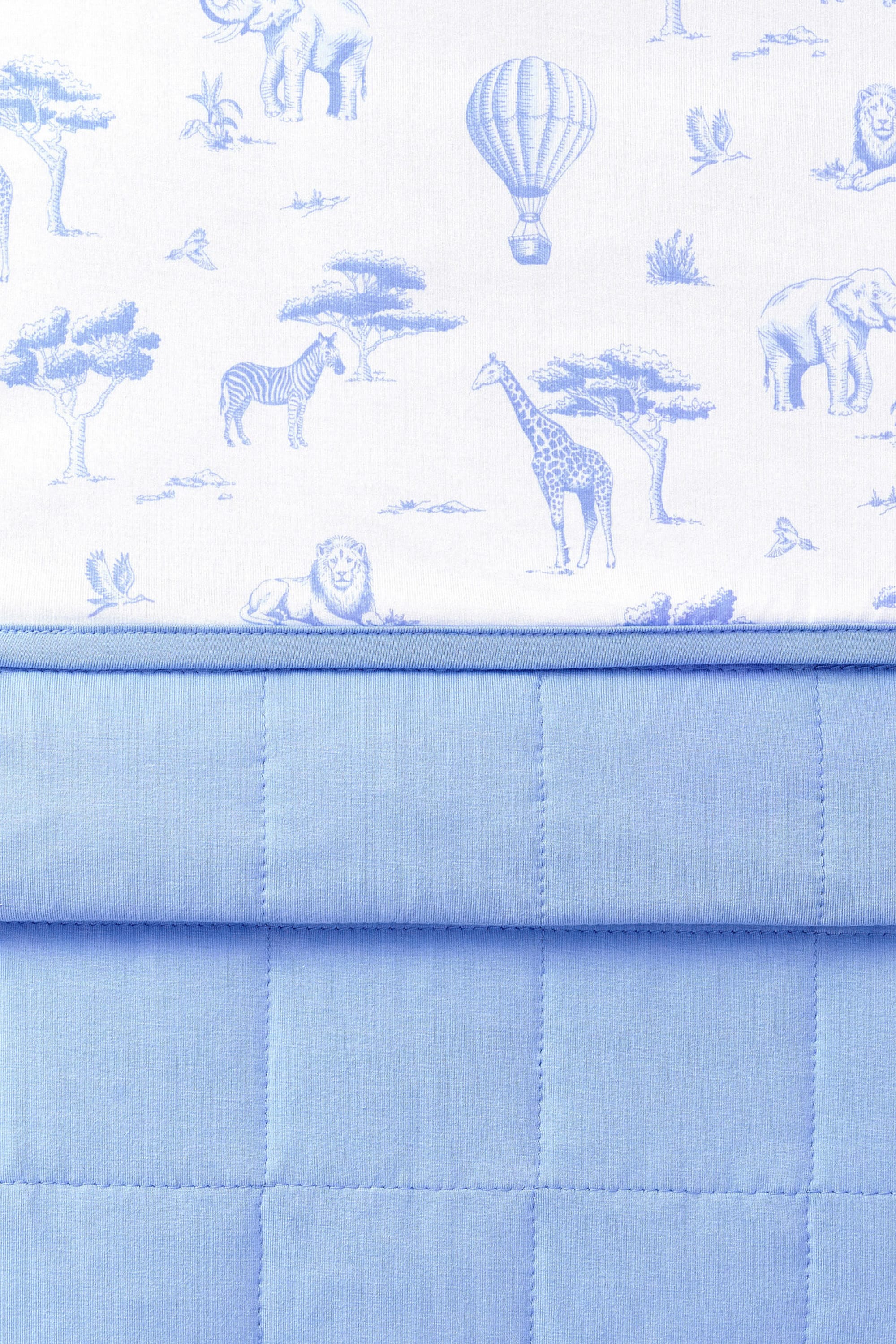 Close up of the Baby Blanket in Toile Safari showing the quilted blue backing and smooth printed top layer
