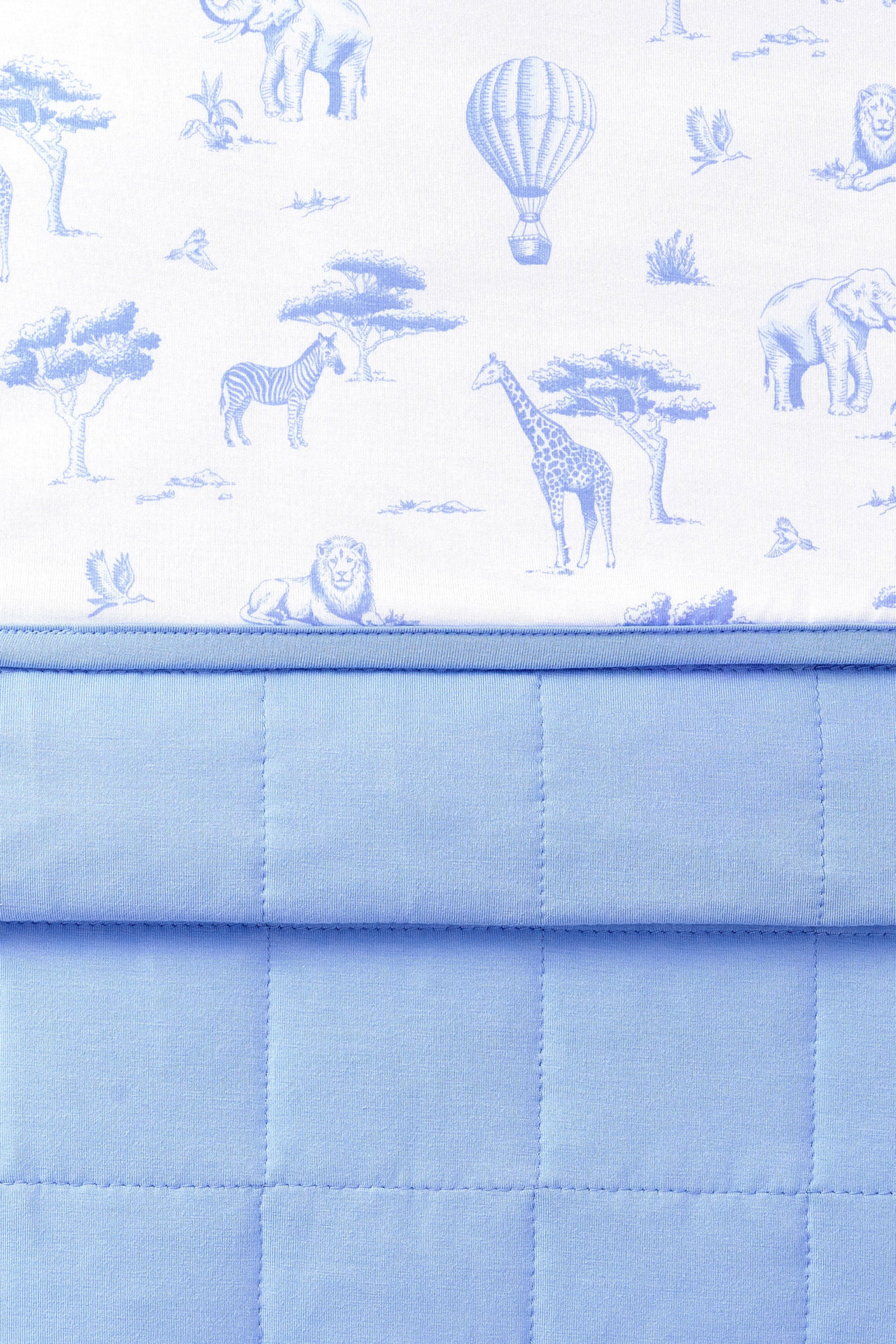 Close up of the Baby Blanket in Toile Safari showing the quilted blue backing and smooth printed top layer