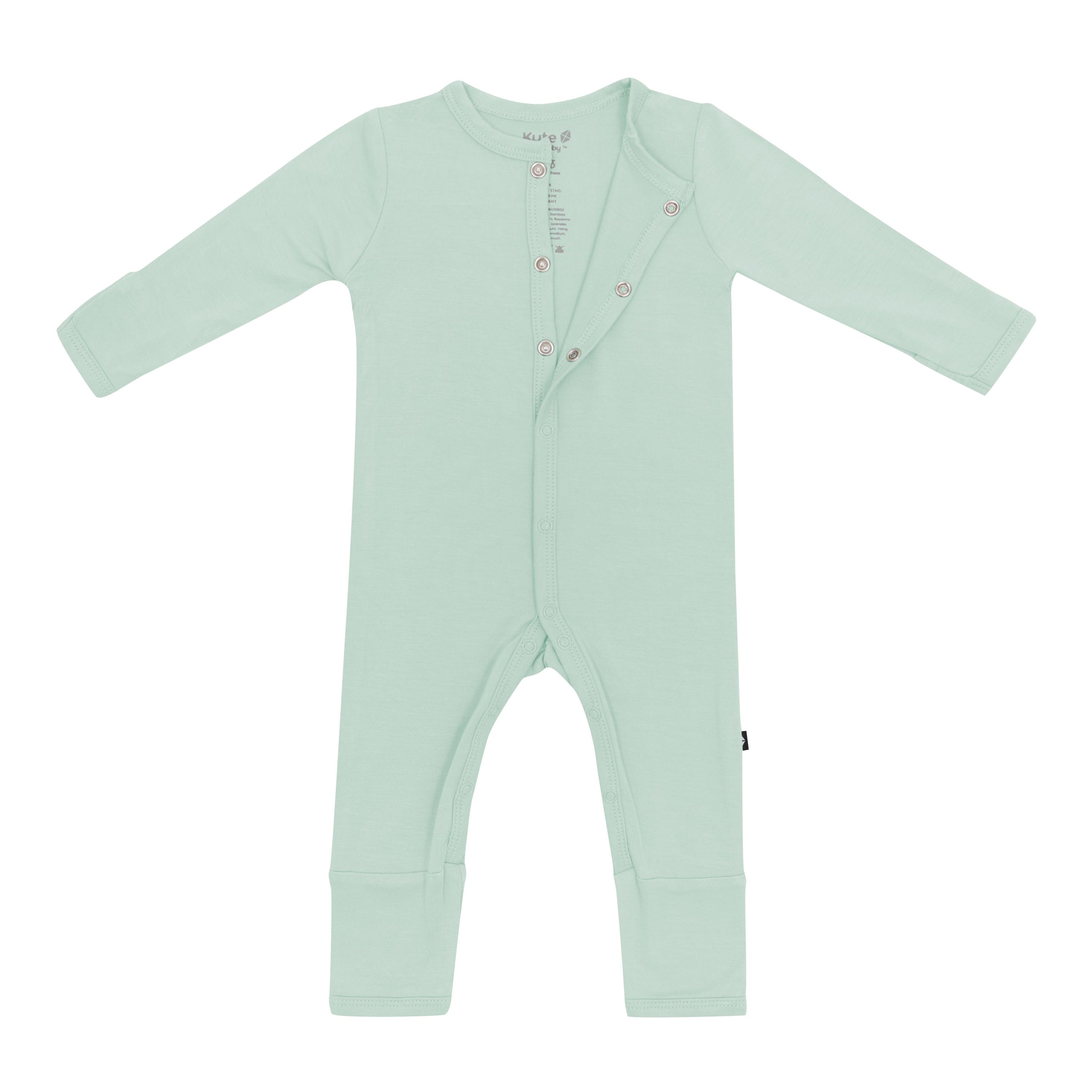 Flat lay of Kyte Baby Romper in Sage with top snaps opened