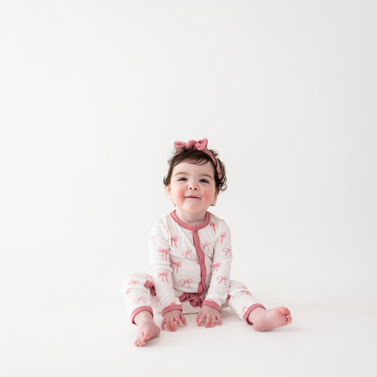 Toddler girl wearing Romper in Bow and Apple Blossom bow