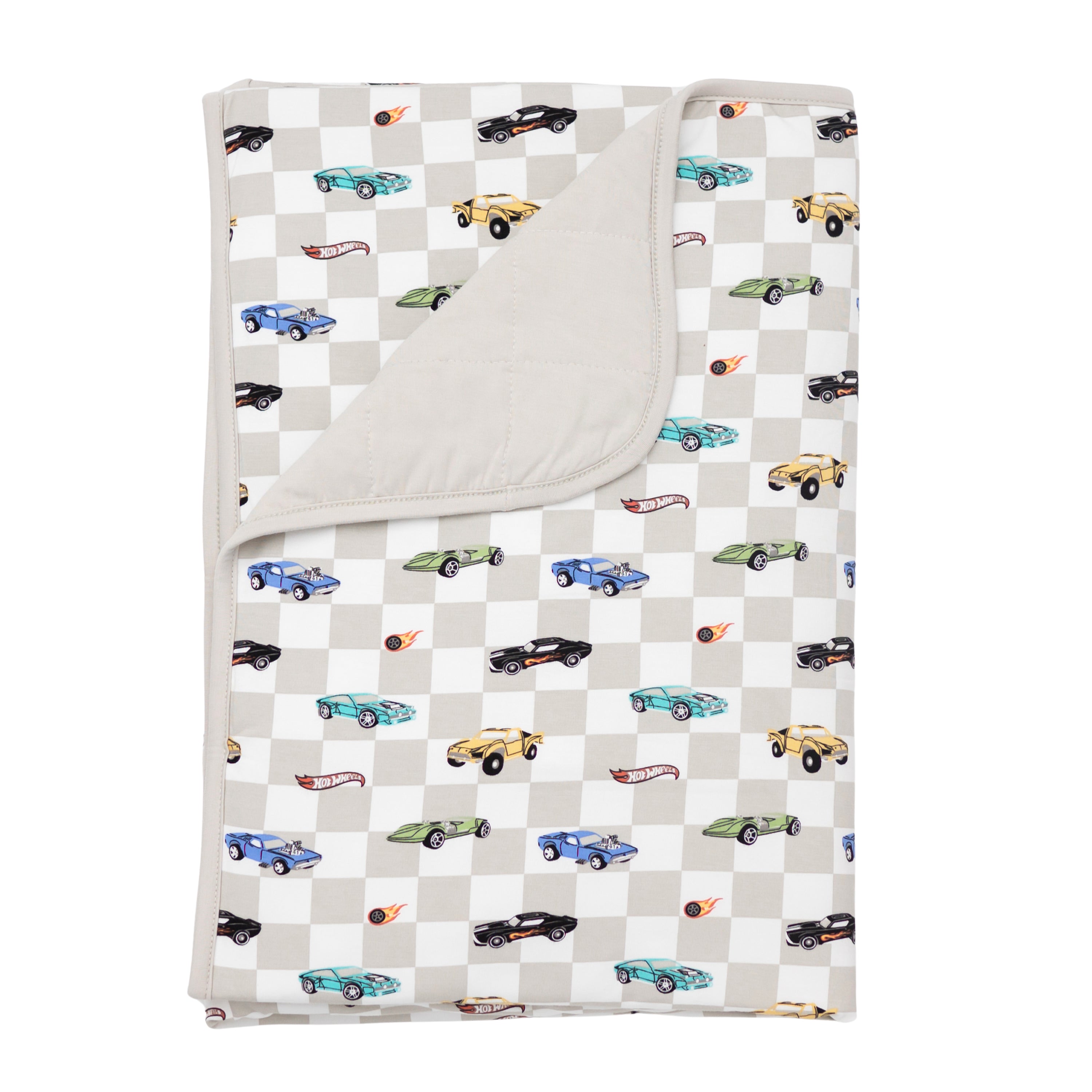 Kyte Baby's Toddler Blanket in Fast and Fierce 1.0 with corner flipped down showing the Oat colored backing