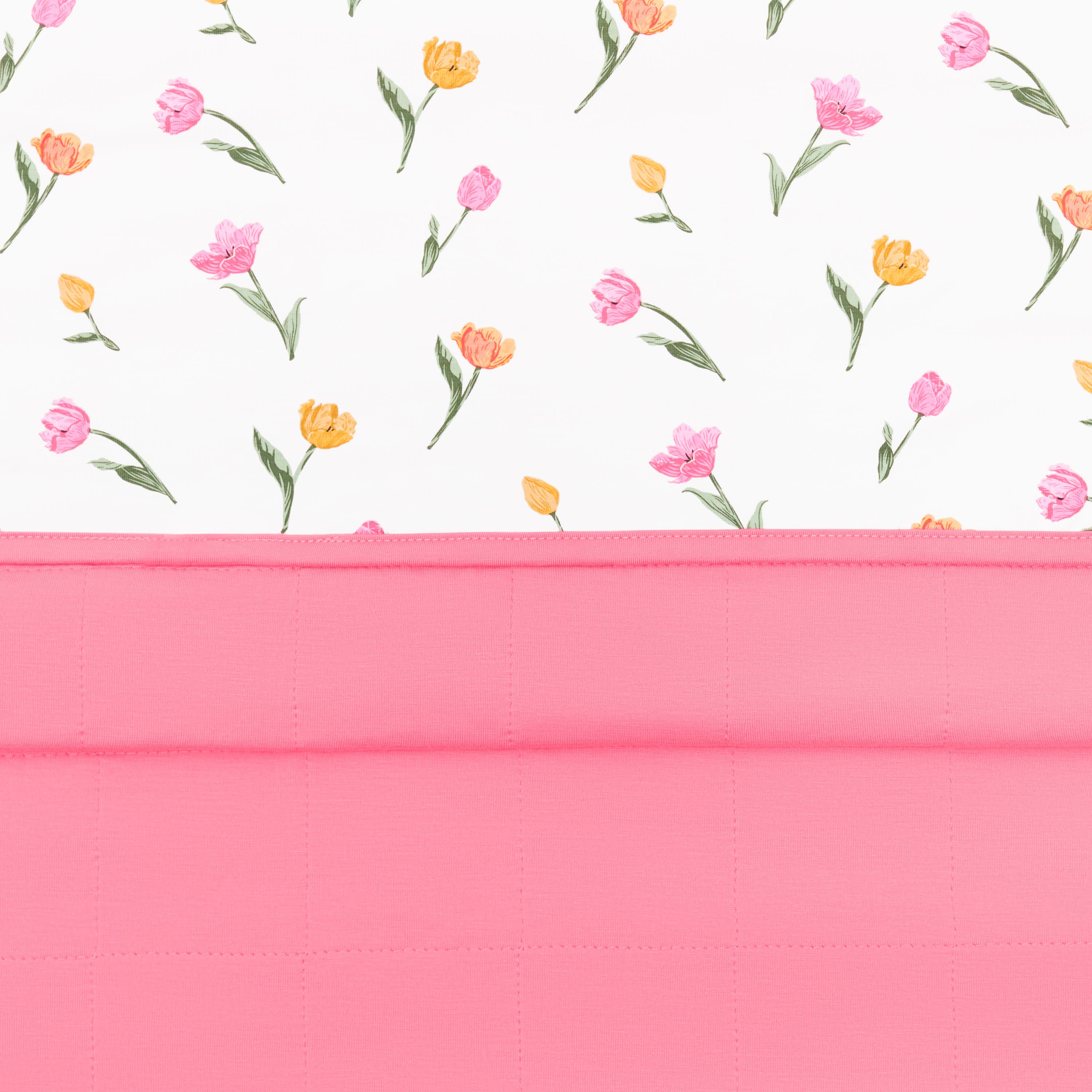 Close up of the Toddler Blanket in Tulip 1.0 showing the quilted pink backing and top floral smooth top layer