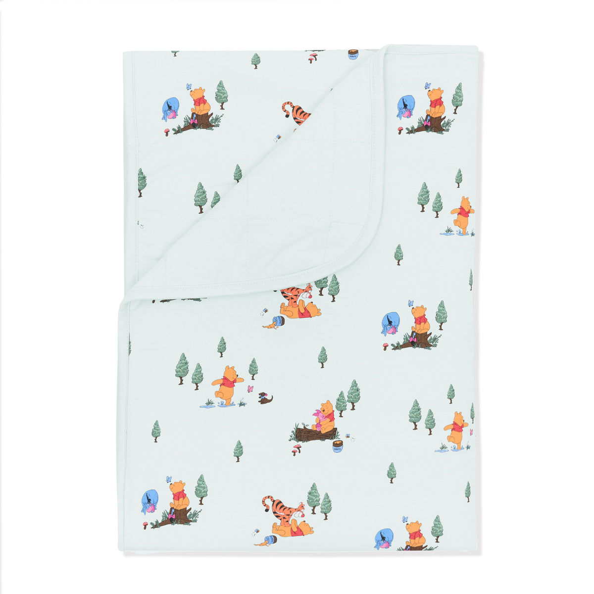 Toddler Blanket in Winnie the Pooh Hundred Acre Wood 1.0 with the corner folded down showing the light green backing
