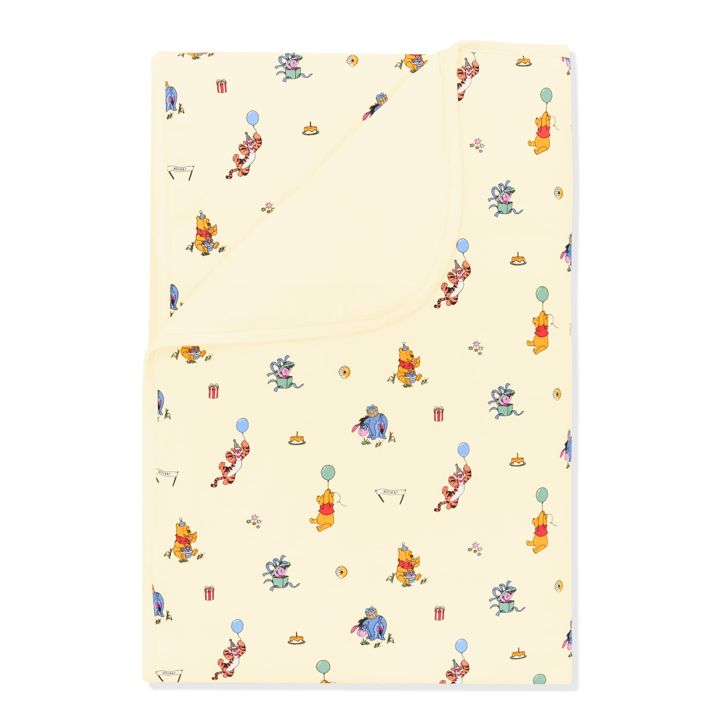 Toddler Blanket in Winnie the Pooh Celebration 1.0 with the corner folded down showing the light yellow backing