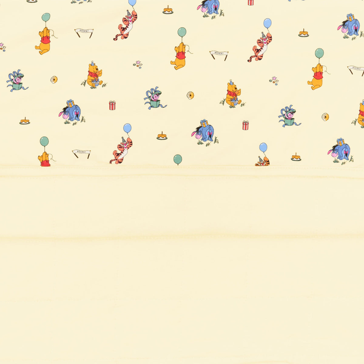 Close up of the Toddler Blanket in Winnie the Pooh Celebration 1.0 showing the quilted yellow backing and printed smooth top layer