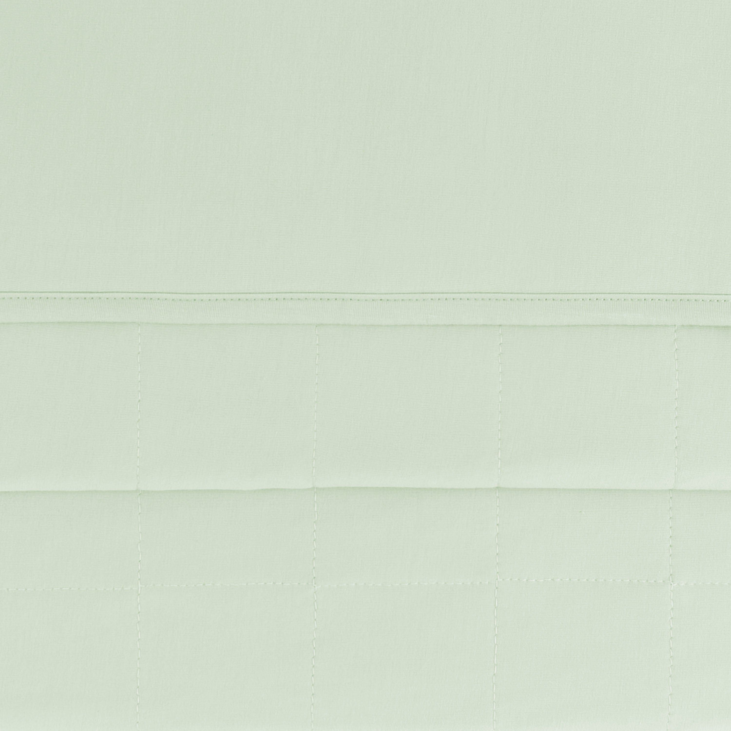 close up of the quilted backing and smooth top layer of the Toddler Blanket in Basil 1.0