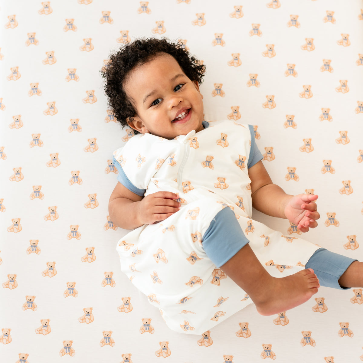 Young toddler wearing Sleep Bag Walker in Teddy Bear laying in crib with Crib Sheet in Teddy Bear on