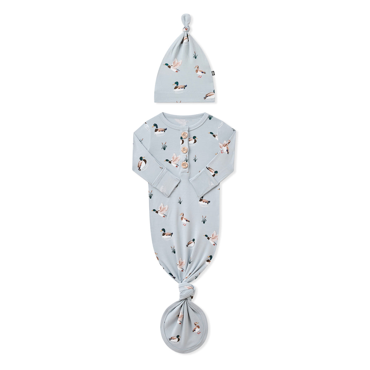 Knotted Gown with Hat Set in Mallard Duck with the arms folded inward laying on a white surface