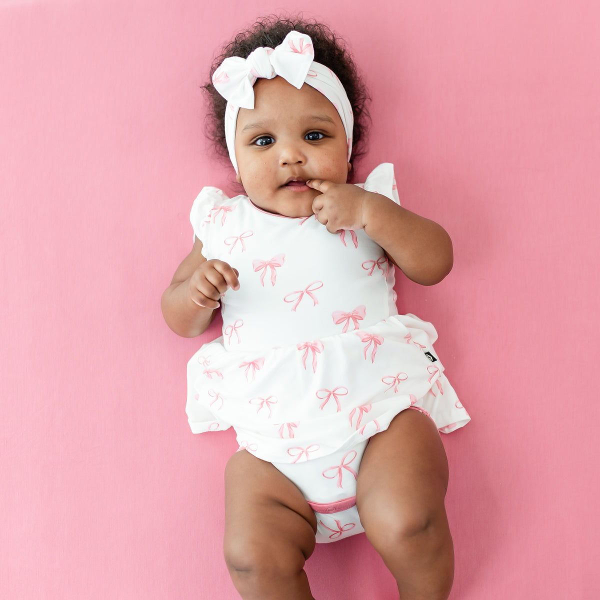 Baby wearing Twirl Bodysuit Dress in Bow with matching headband