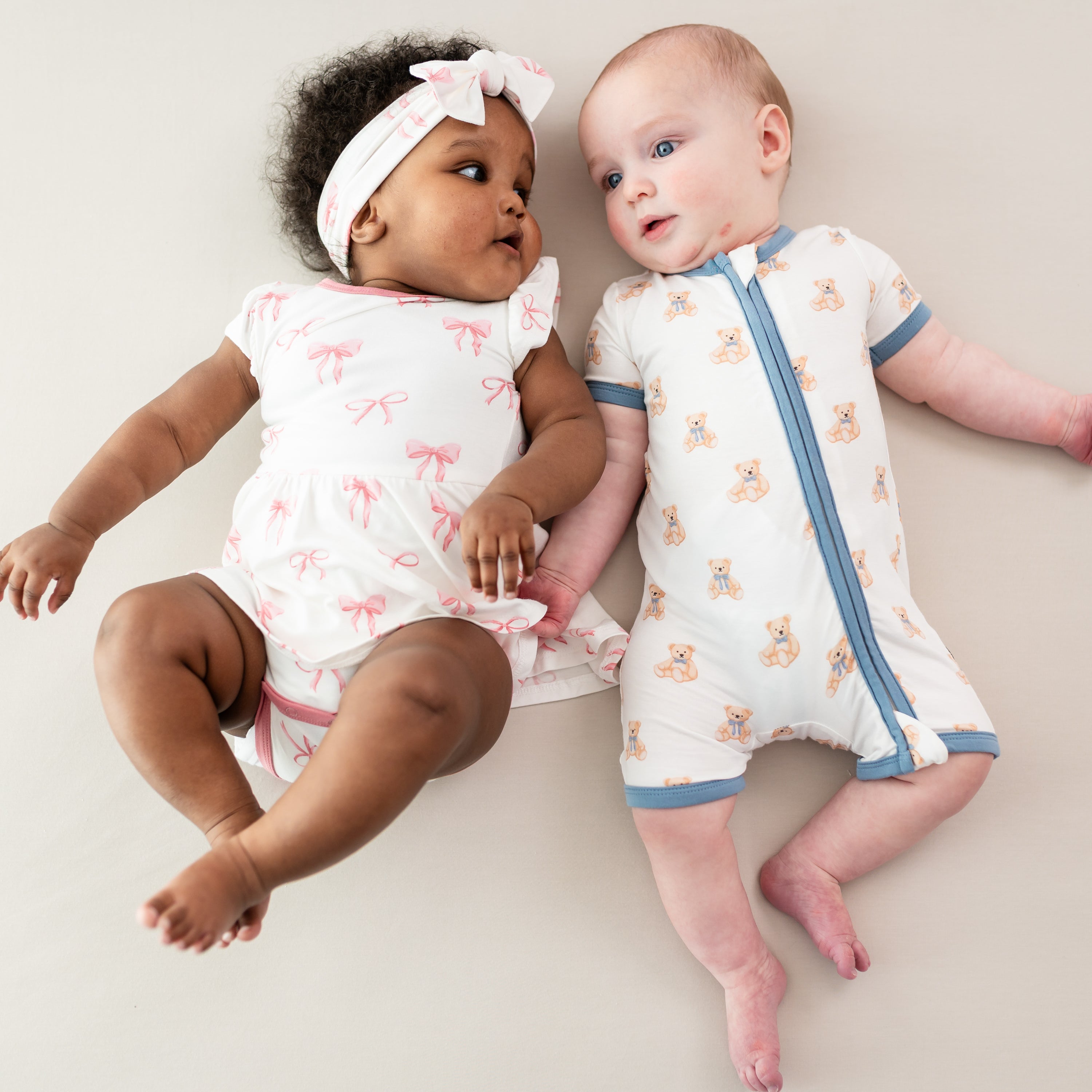 Babies wearing Twirl Bodysuit Dress in Bow and Zippered Shortall Romper in Teddy Bear
