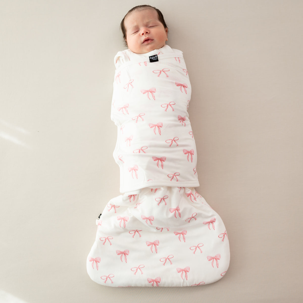 Baby asleep wearing Sleep Bag Swaddler in Bow 1.0