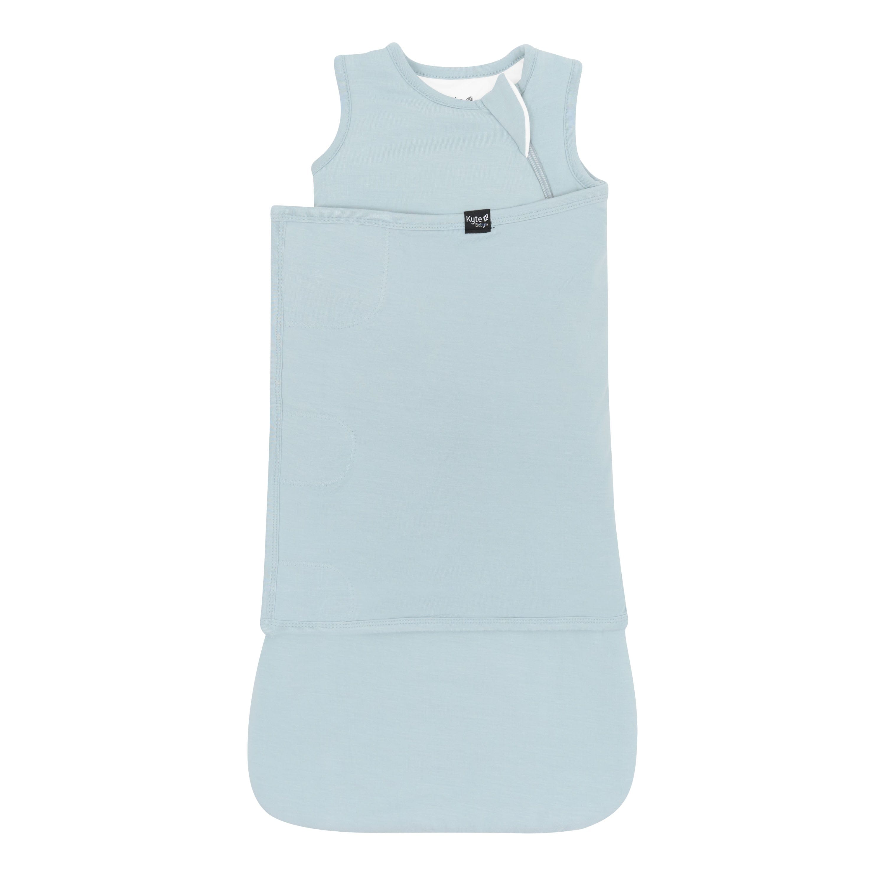 Sleep Bag Swaddler in Fog 1.0 shown swaddled with the Black Kyte Baby logo visible