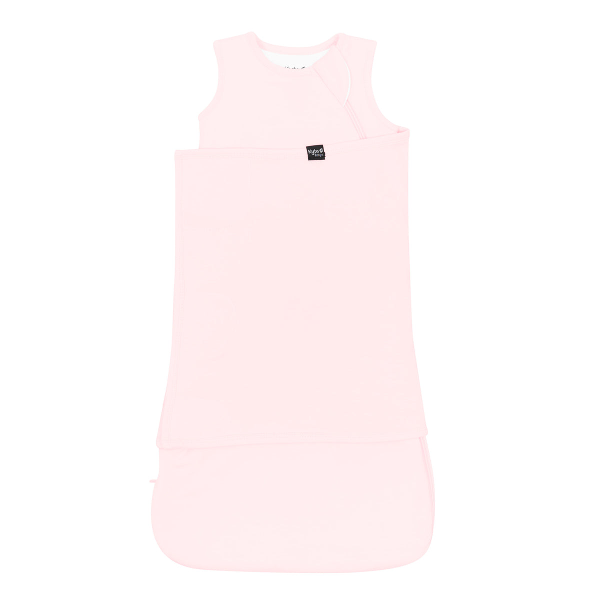 Sleep Bag Swaddler in Sakura 1.0 shown swaddled with the Black Kyte Baby logo tag visible