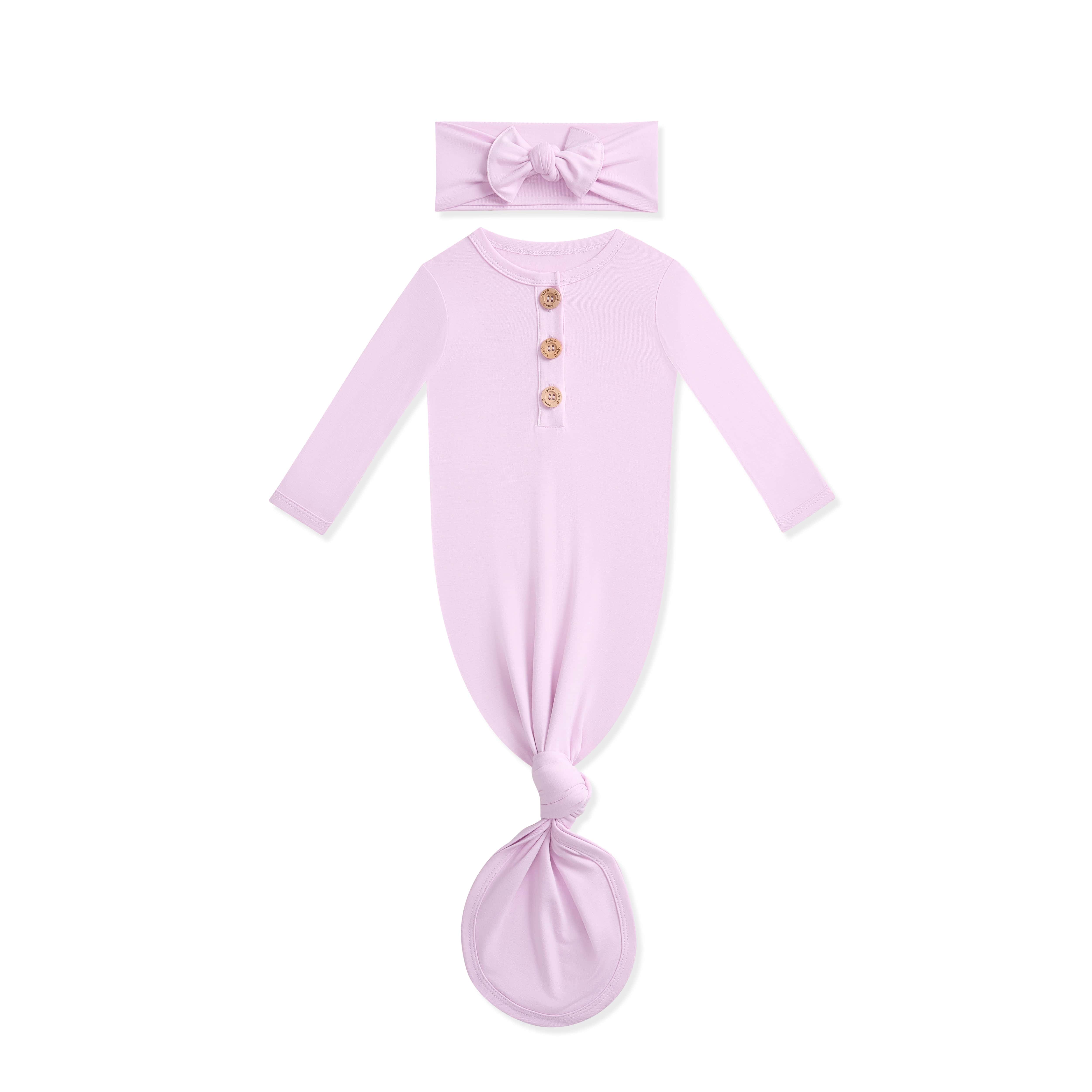 Lavender baby knotted gown with wooden buttons and matching headband on a white background