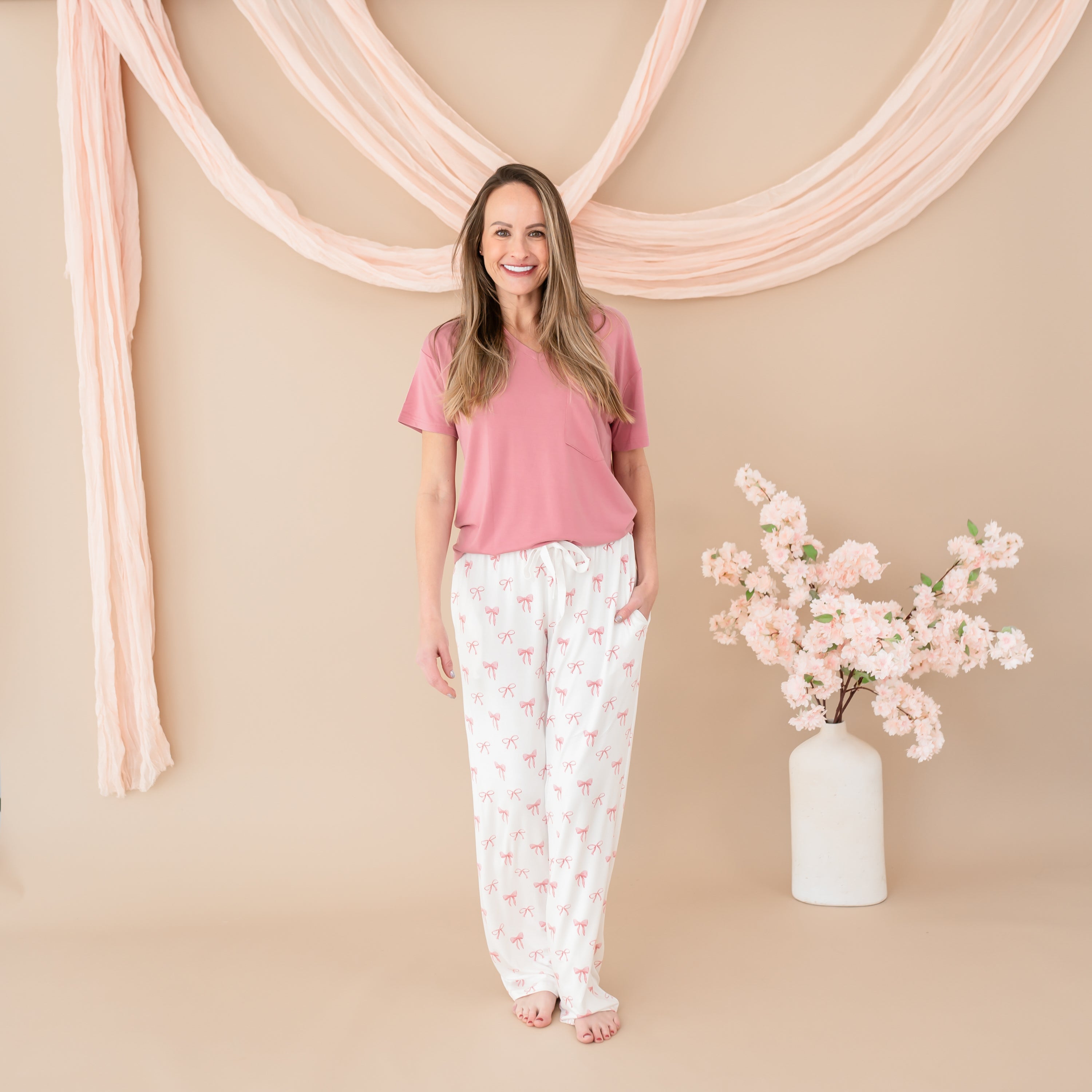 Woman modeling Women's Lounge Pants in Bow with Apple Blossom V-Neck with hand in pocket