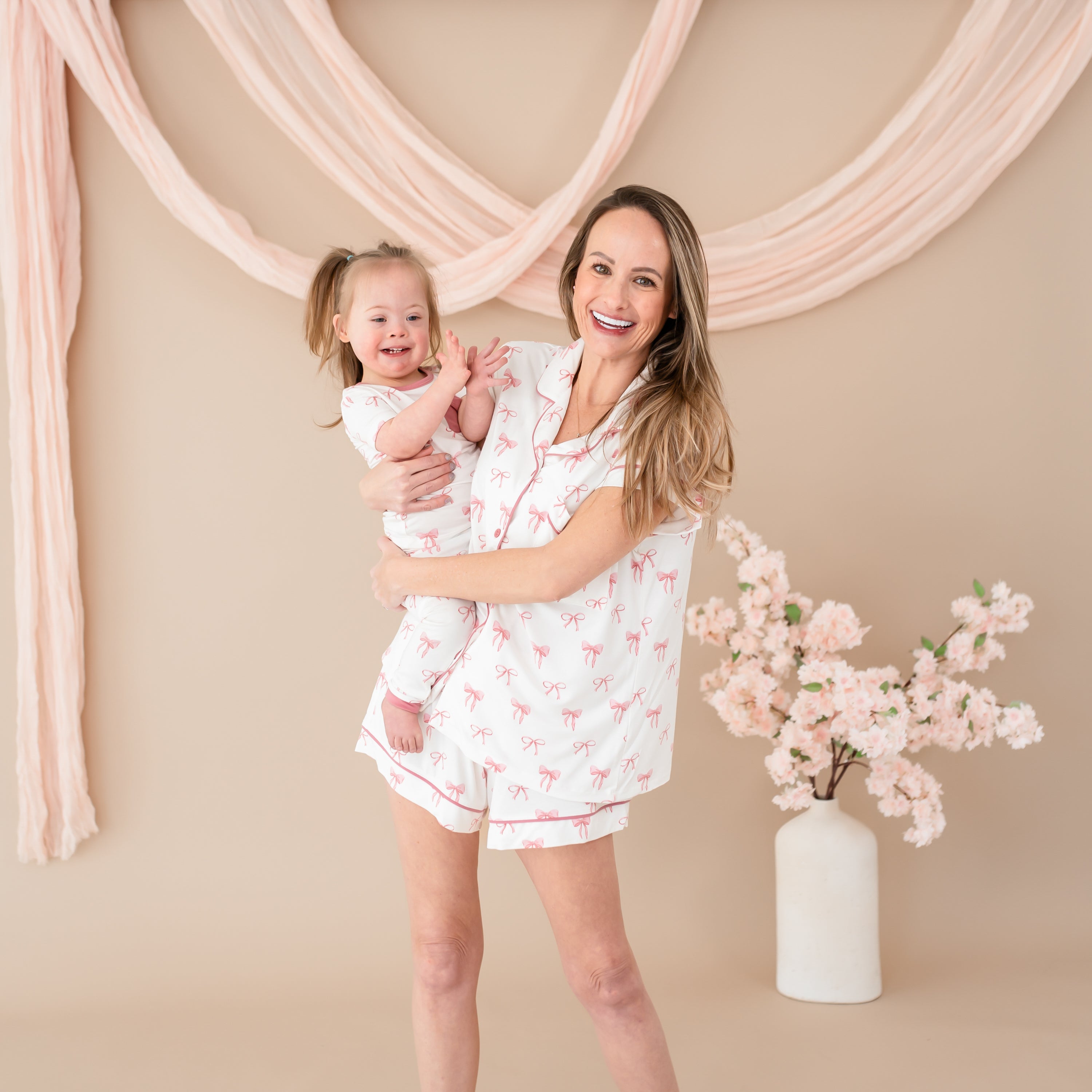 Woman wearing Women’s Short Sleeve Pajama Set in Bow while holding toddler wearing matching pajamas