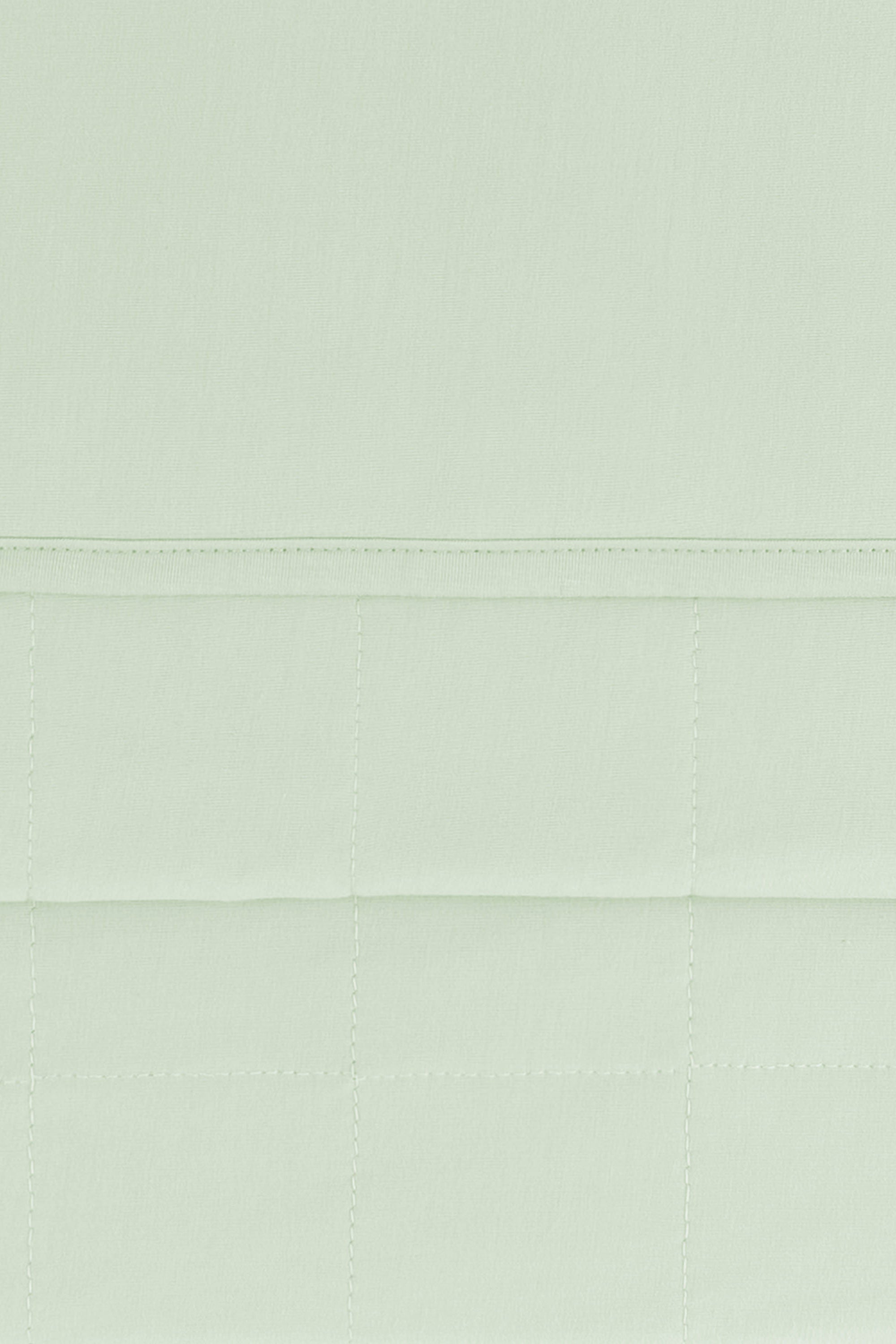 Close up of the Youth Blanket in Basil 1.0 showing the quilted backing and smooth top layer