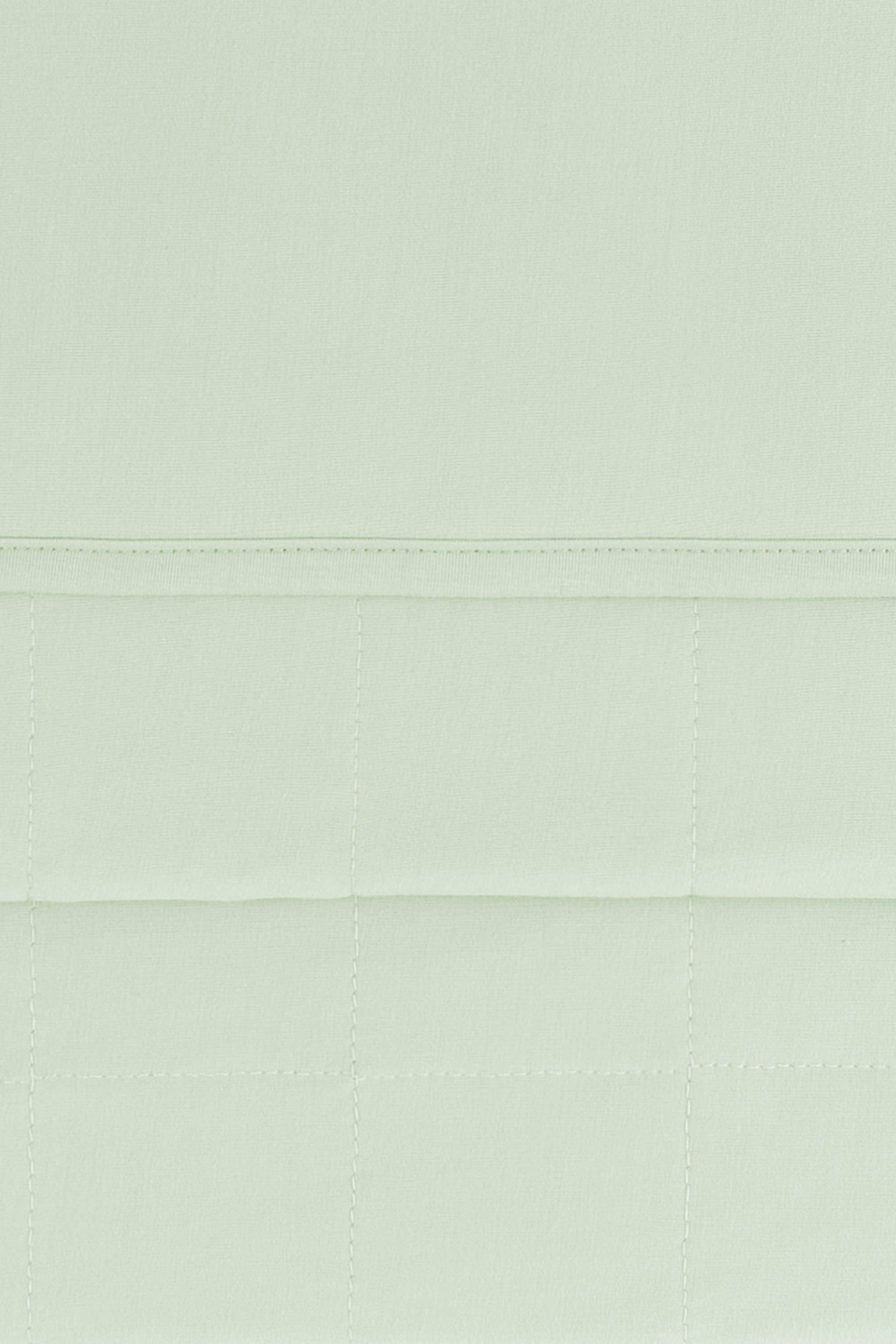 Close up of the Youth Blanket in Basil 1.0 showing the quilted backing and smooth top layer