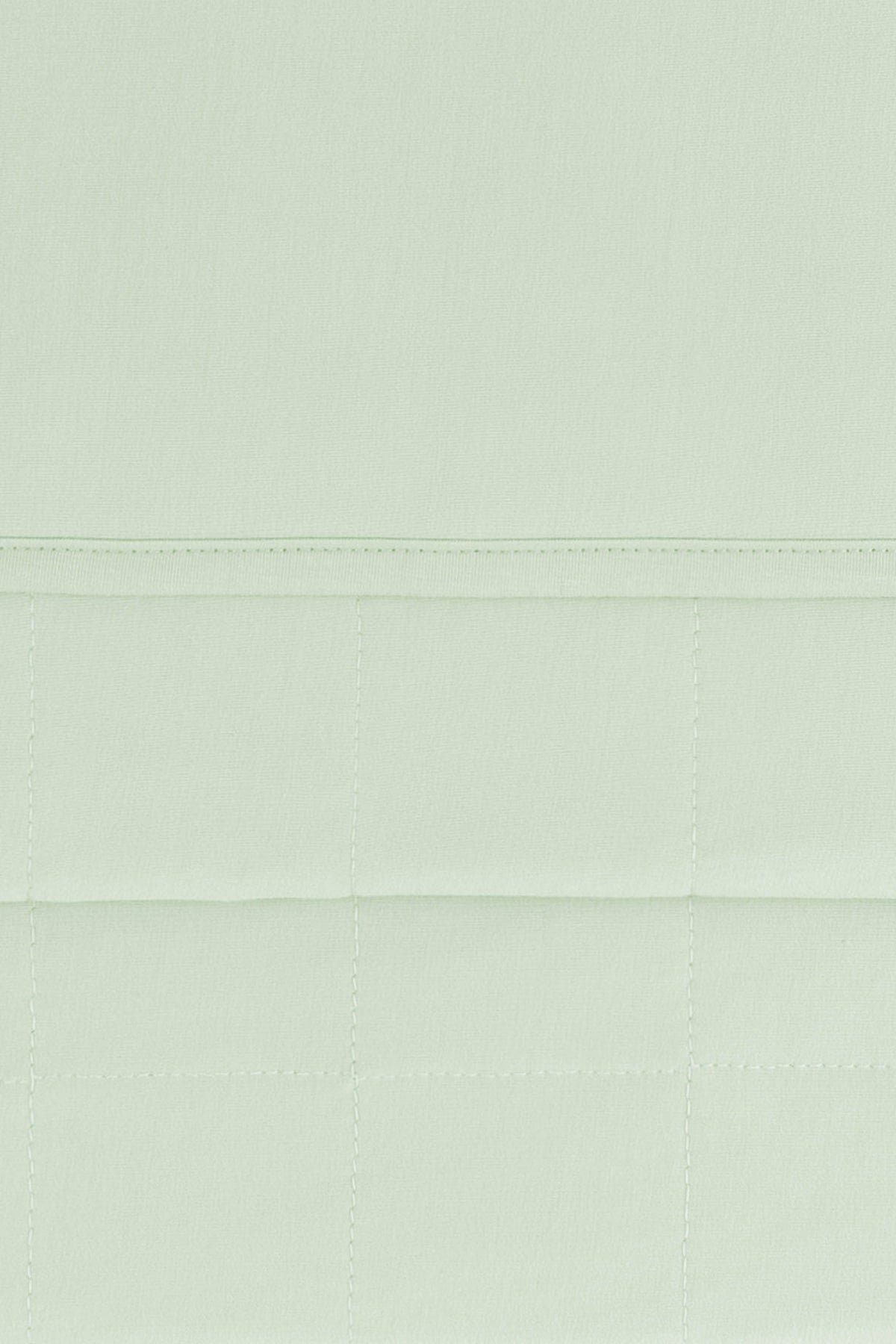 Close up of the Youth Blanket in Basil 1.0 showing the quilted backing and smooth top layer