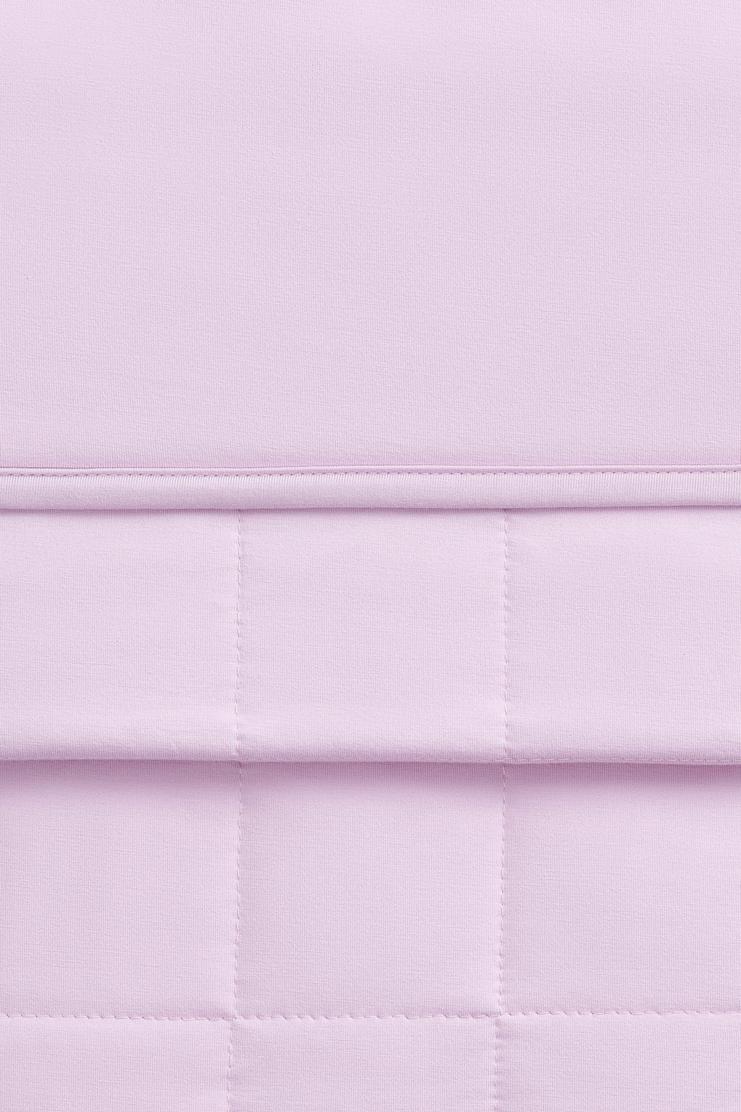 Close up of the Youth Blanket in Thistle 1.0 showing the quilted backing and smooth top layer