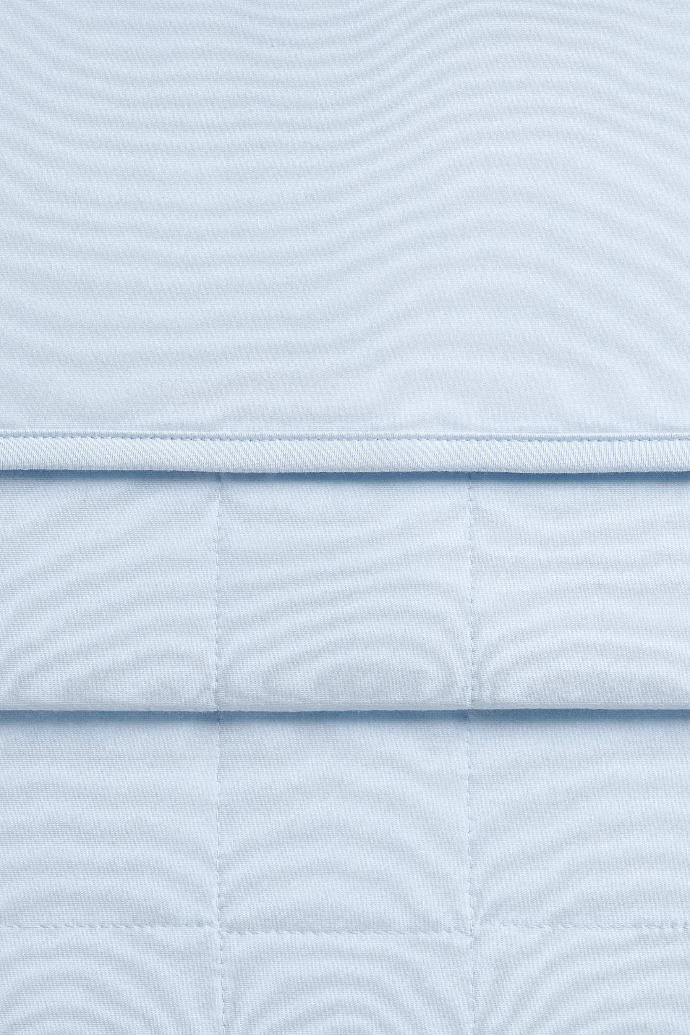 Close up of the Youth Blanket in Breeze 1.0 showing the quilted backing and smooth top layer