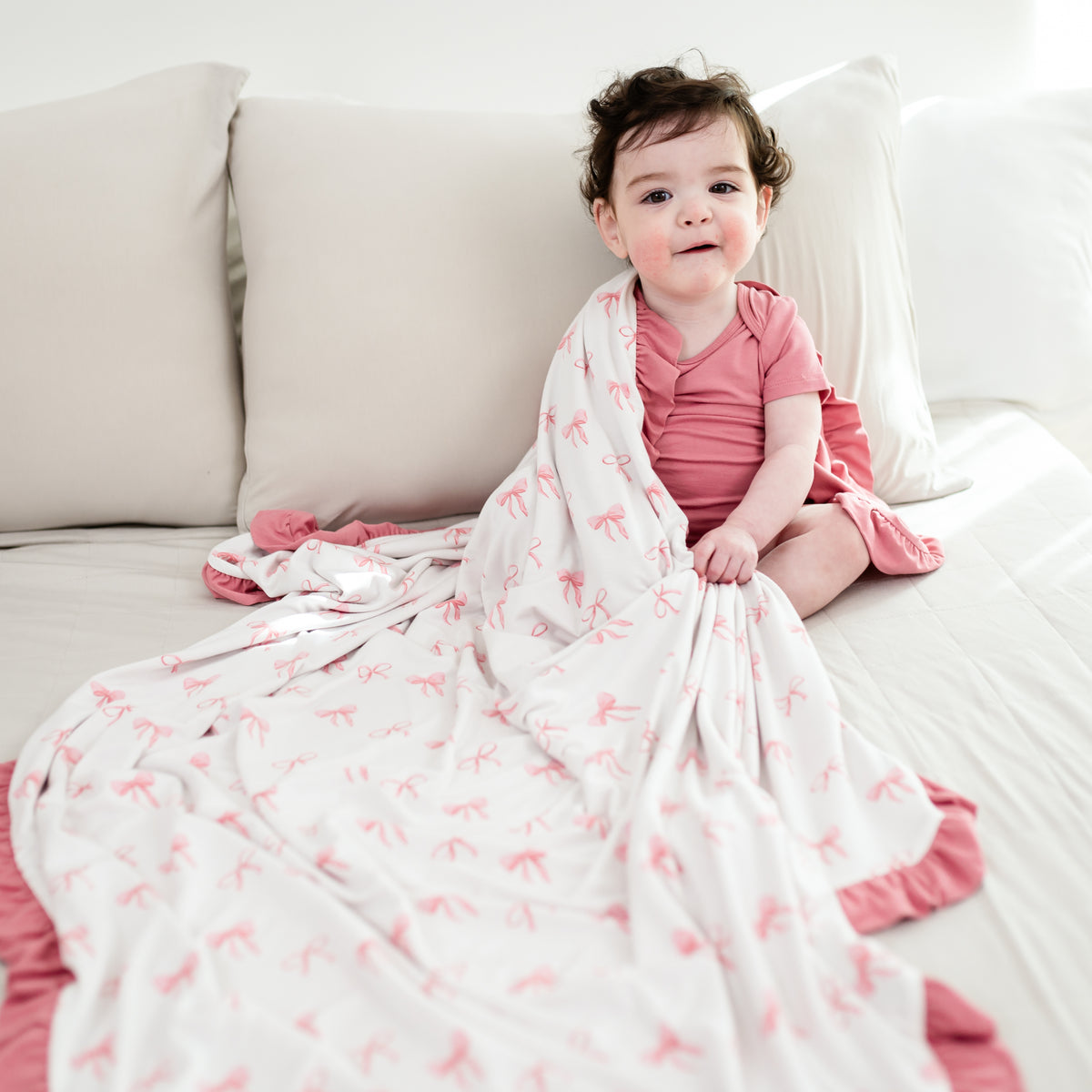 Toddler girl snuggled with Ruffle Toddler Blanket in Bow 0.5