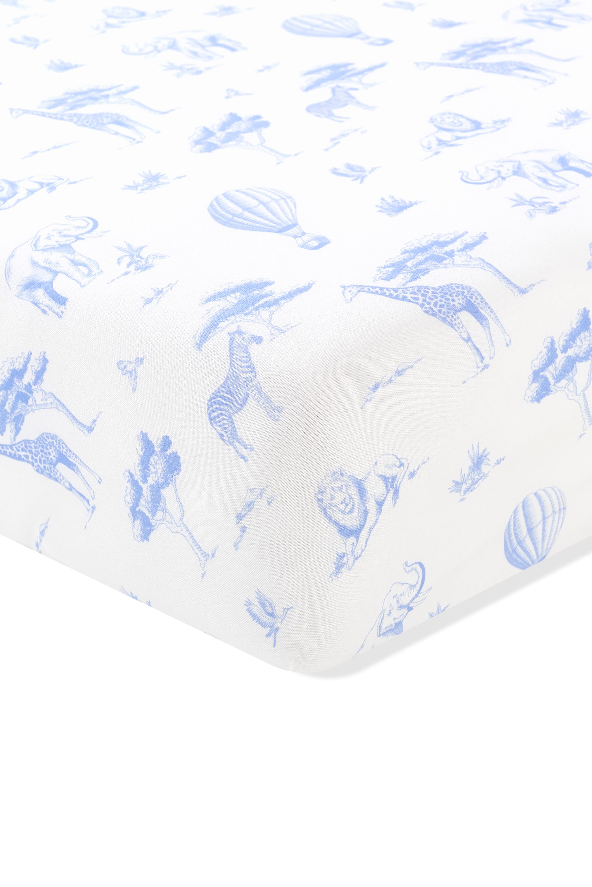 Close up of the corner of the Crib Sheet in Toile Safari shown on a crib mattress