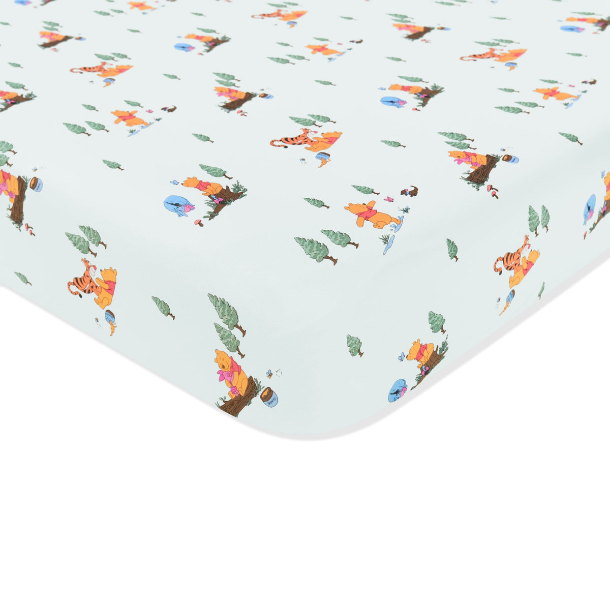 Corner of the Crib Sheet in Winnie the Pooh Hundred Acre Wood shown on a crib mattress
