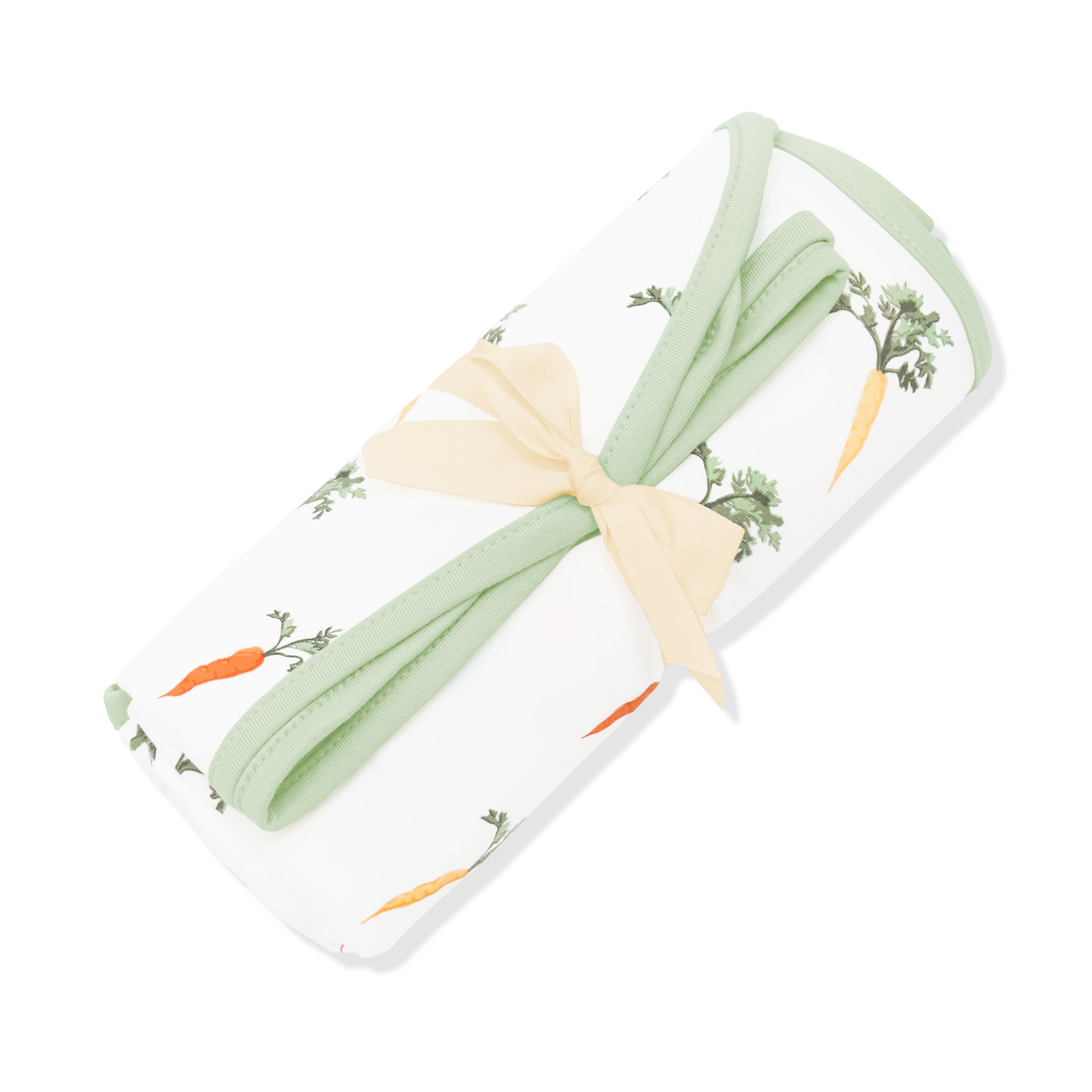 Swaddle Blanket in Carrot shown rolled in its packaging tied with a linen bow