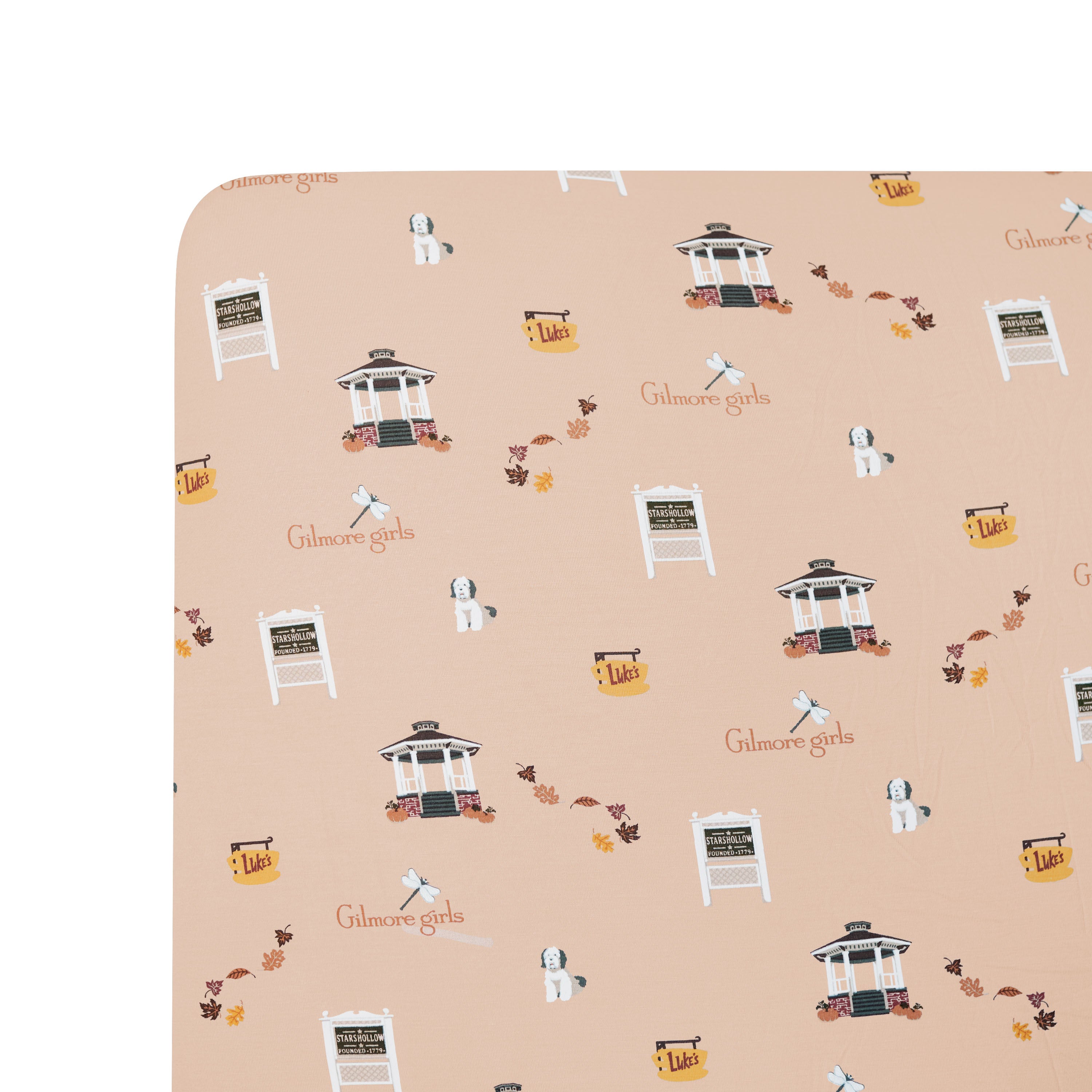 Patterned fabric with 'Gilmore Girls' logo and design elements on a beige background