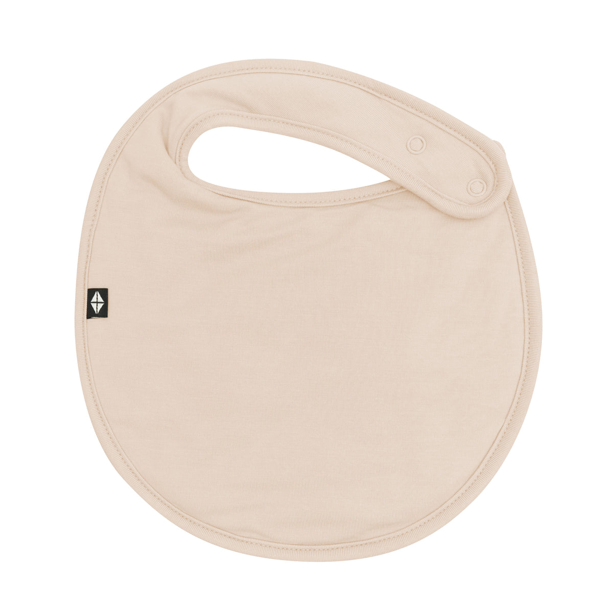 The front of the Cushy Bib in Bisque showing the snap closures