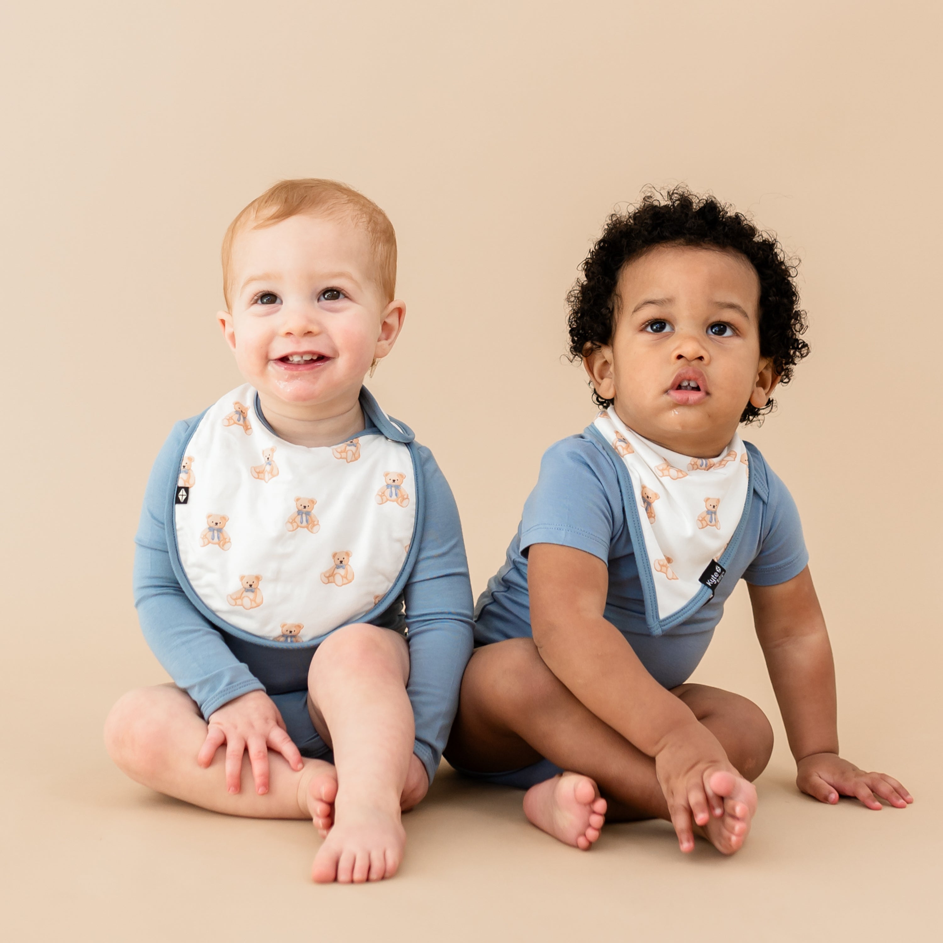 2 toddlers in slate bodysuits and teddy bear bibs