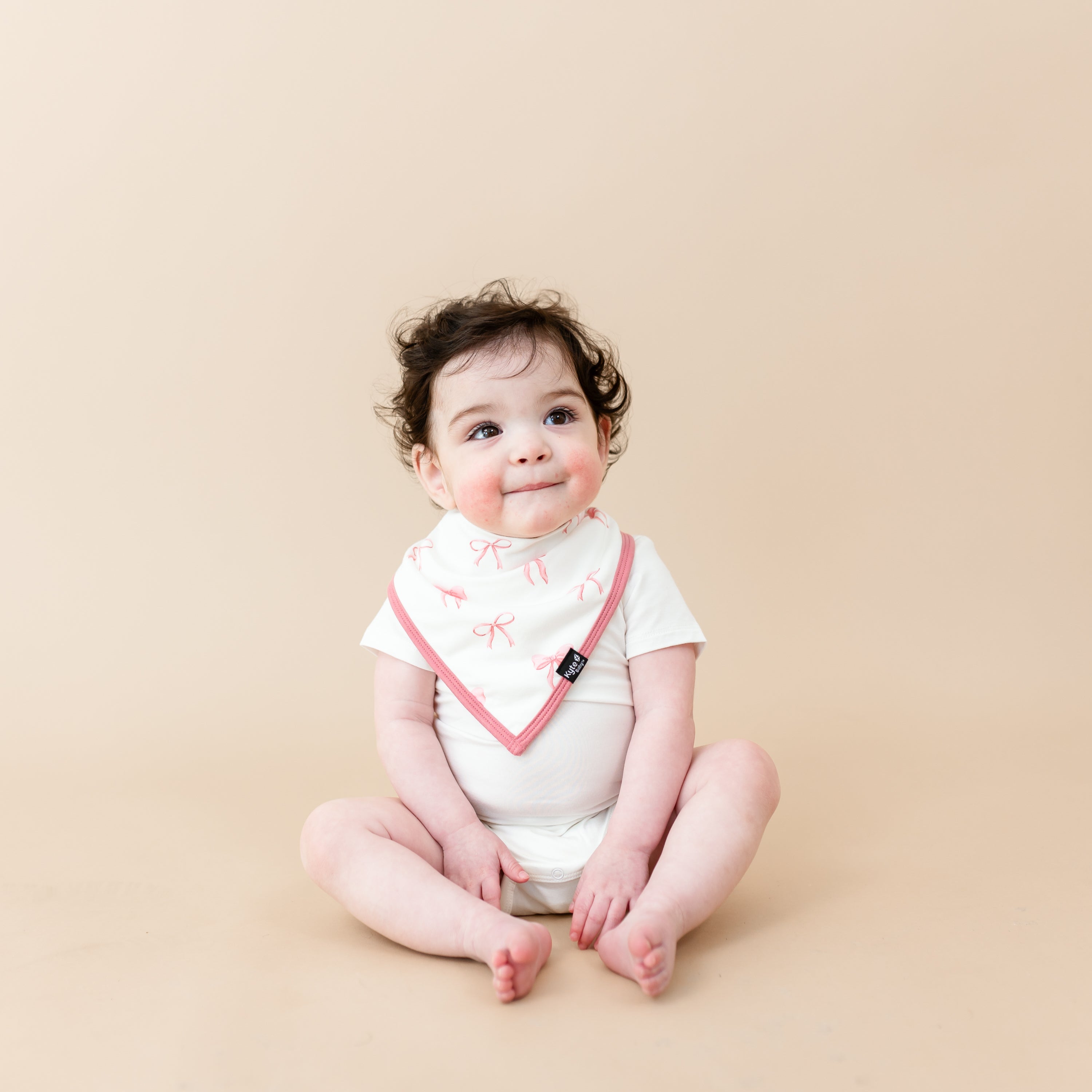 Toddler sitting wearing Cloud Bodysuit and Bib in Bow