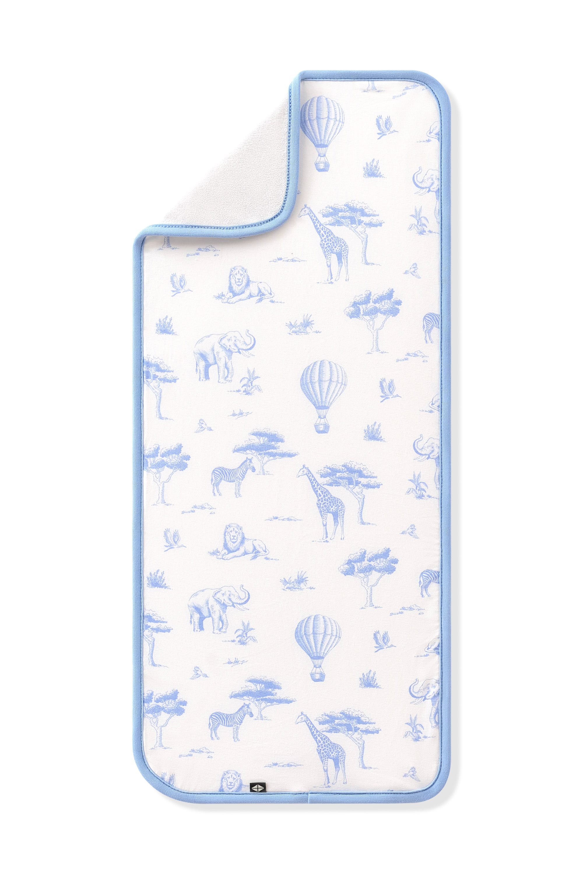 The Burp Cloth in Toile Safari shown laid flat with the corner folded down showing the absorbent bamboo terry backing