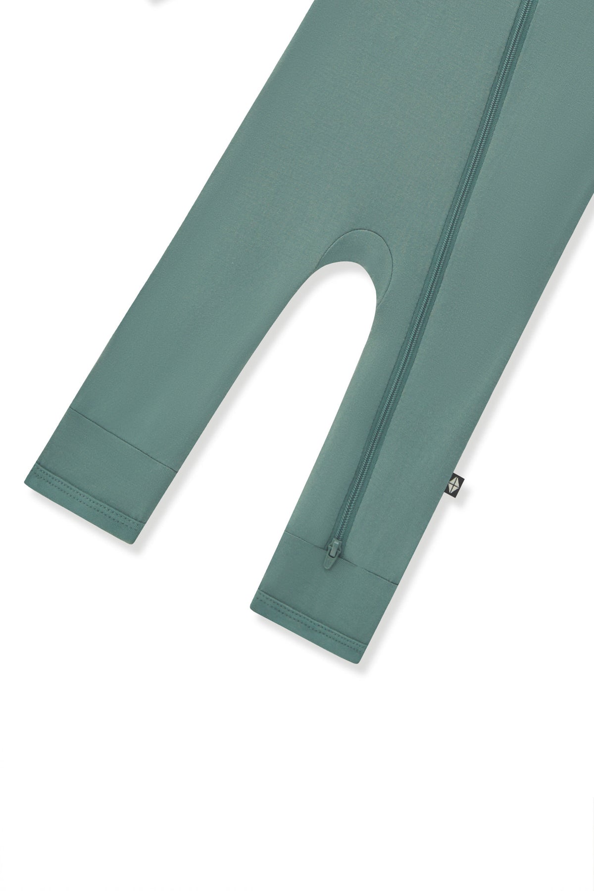 Bottom zipper shown on the leg of the Zippered Romper in Pine on a white background