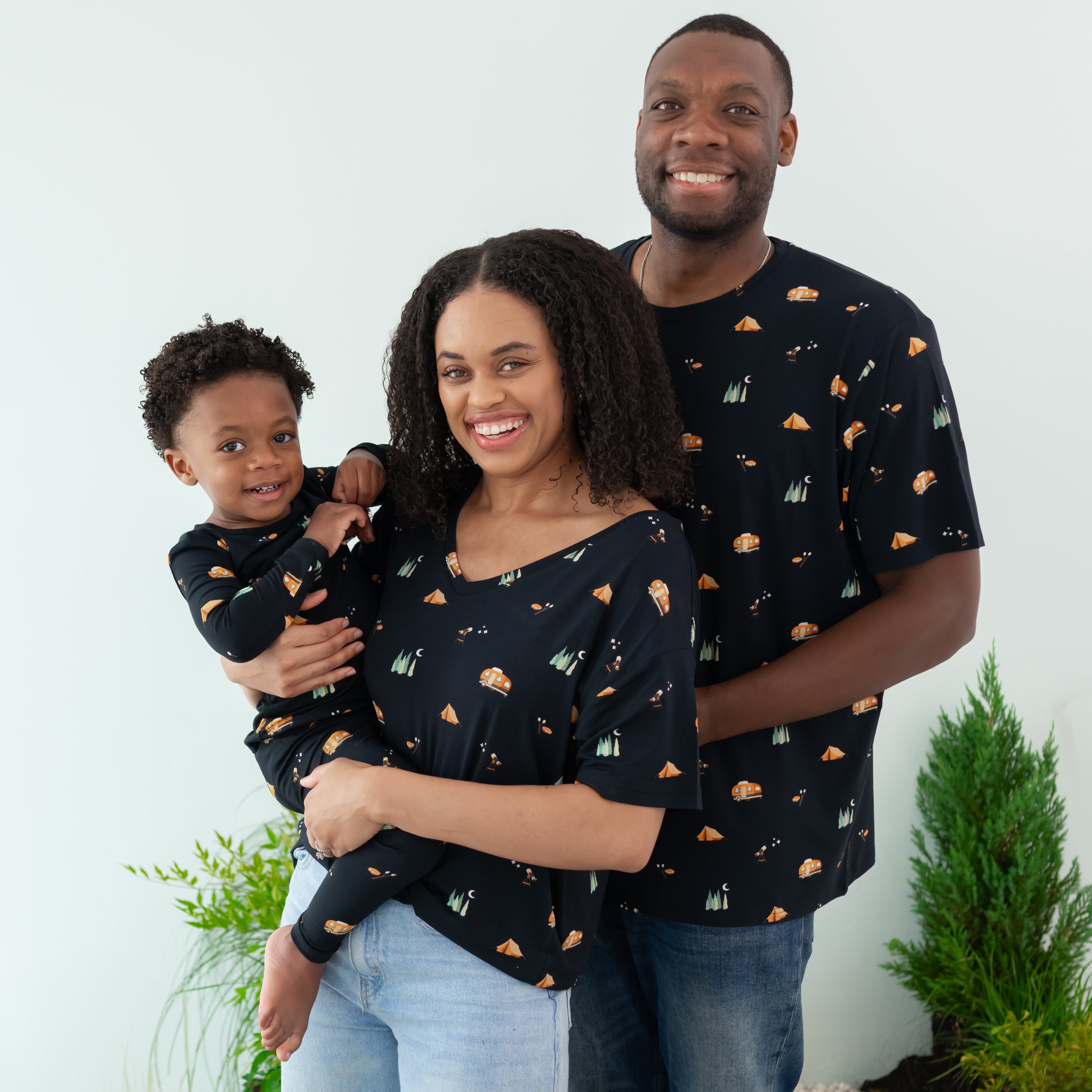 Family wearing Under the Stars collection. Pictured are the long sleeve toddler pajama set, women's relaxed fit v-neck and Men's Crew neck