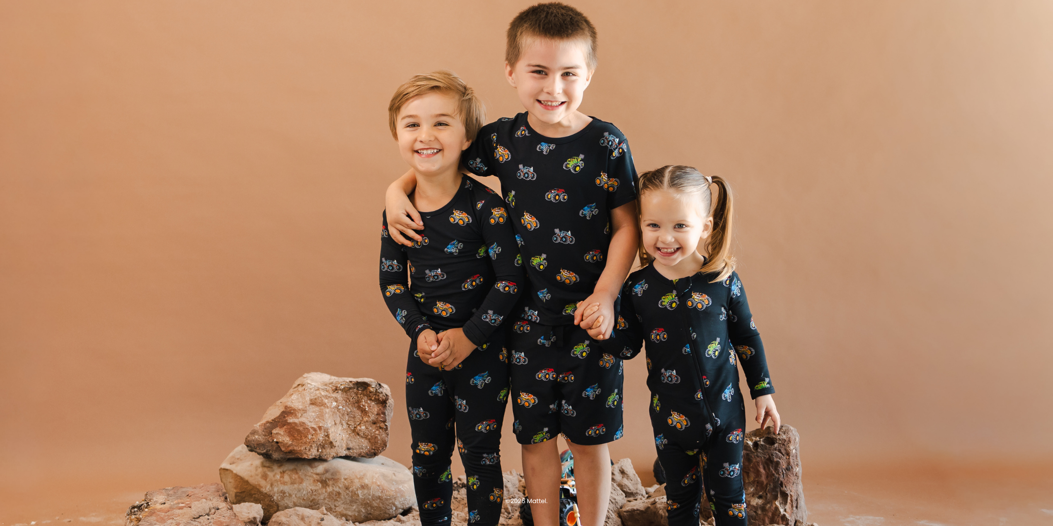 group of 3 kids in monster truck hot wheels by kyte baby collaboration printed pajamas
