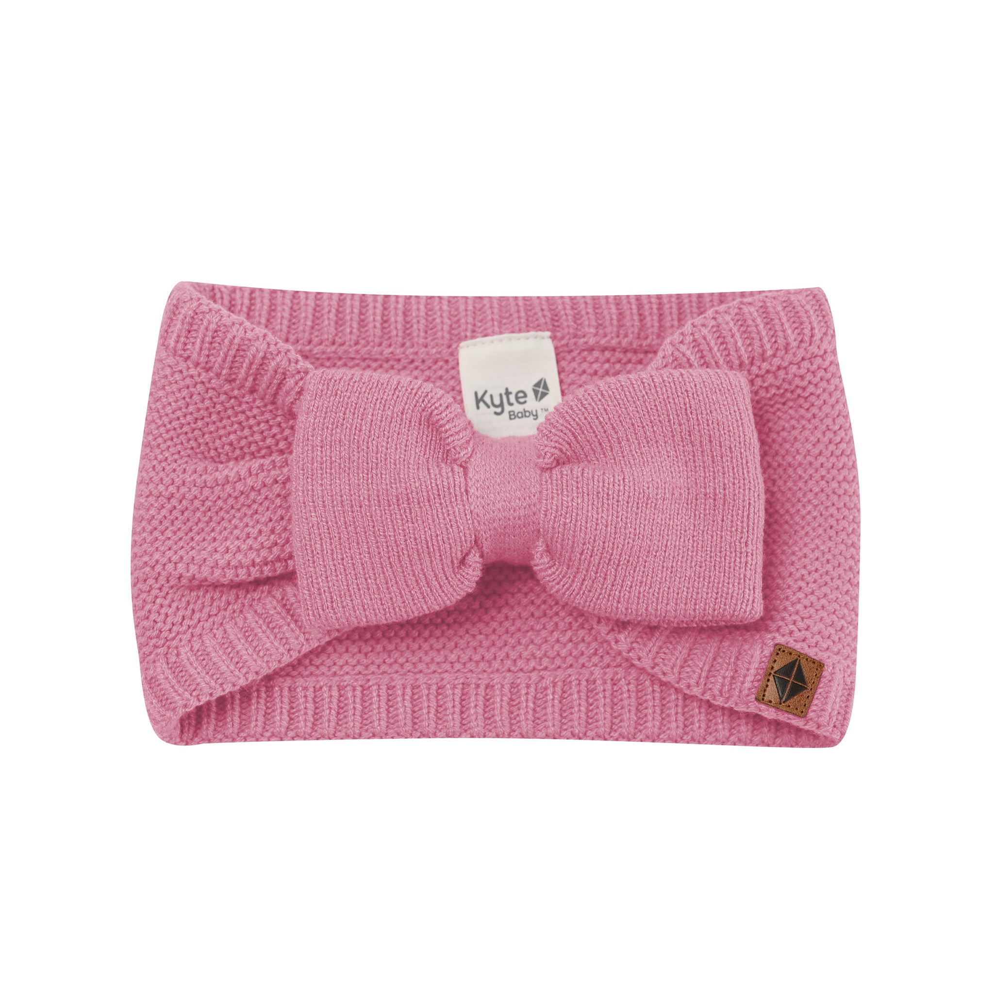 Product photo of the Chunky Knit Bow Headband in Apple Blossom with Kyte Baby vegan leather tag visible