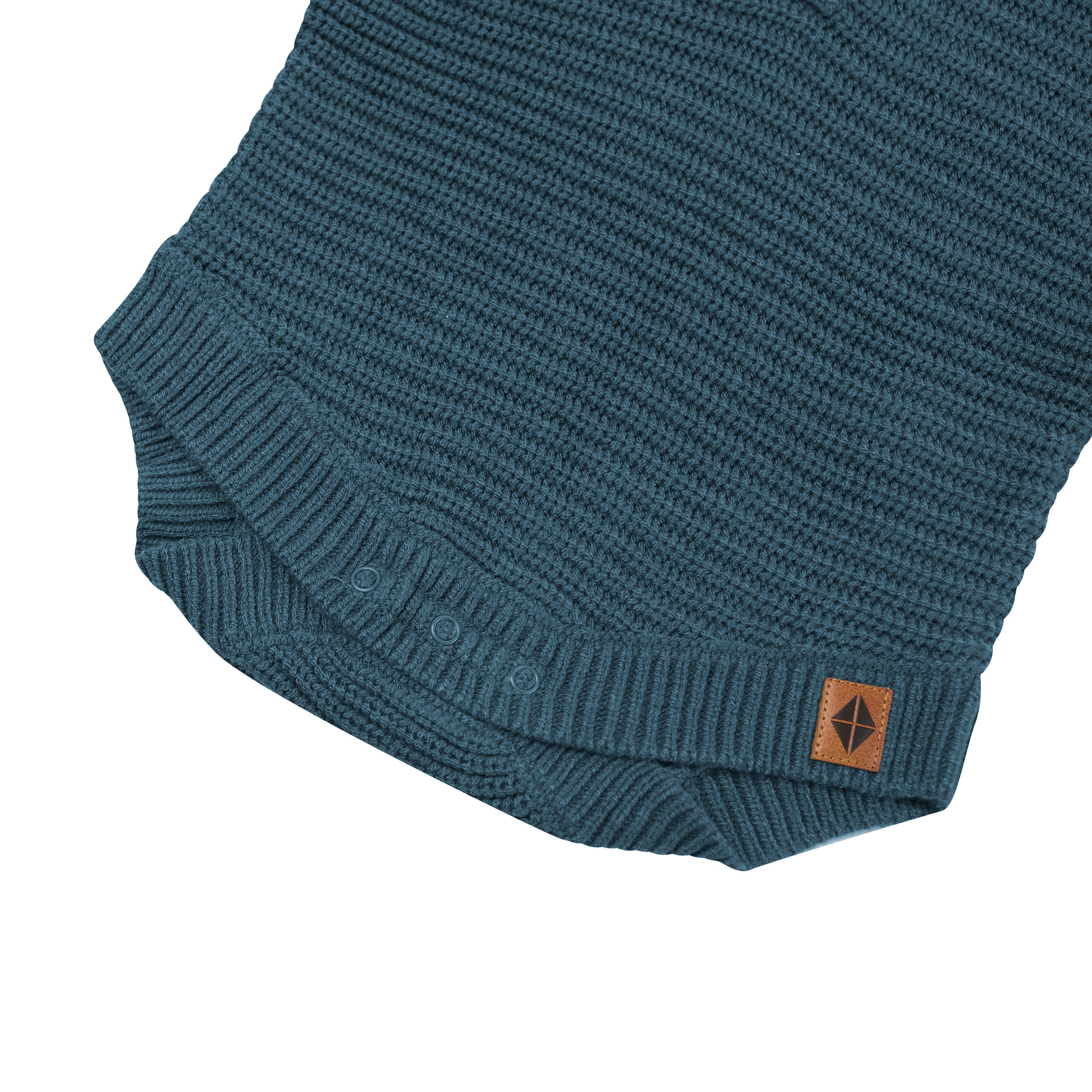 Snap closures shown on the Chunky Knit Romper in Atlantic with the Kyte Baby vegan leather tag visible
