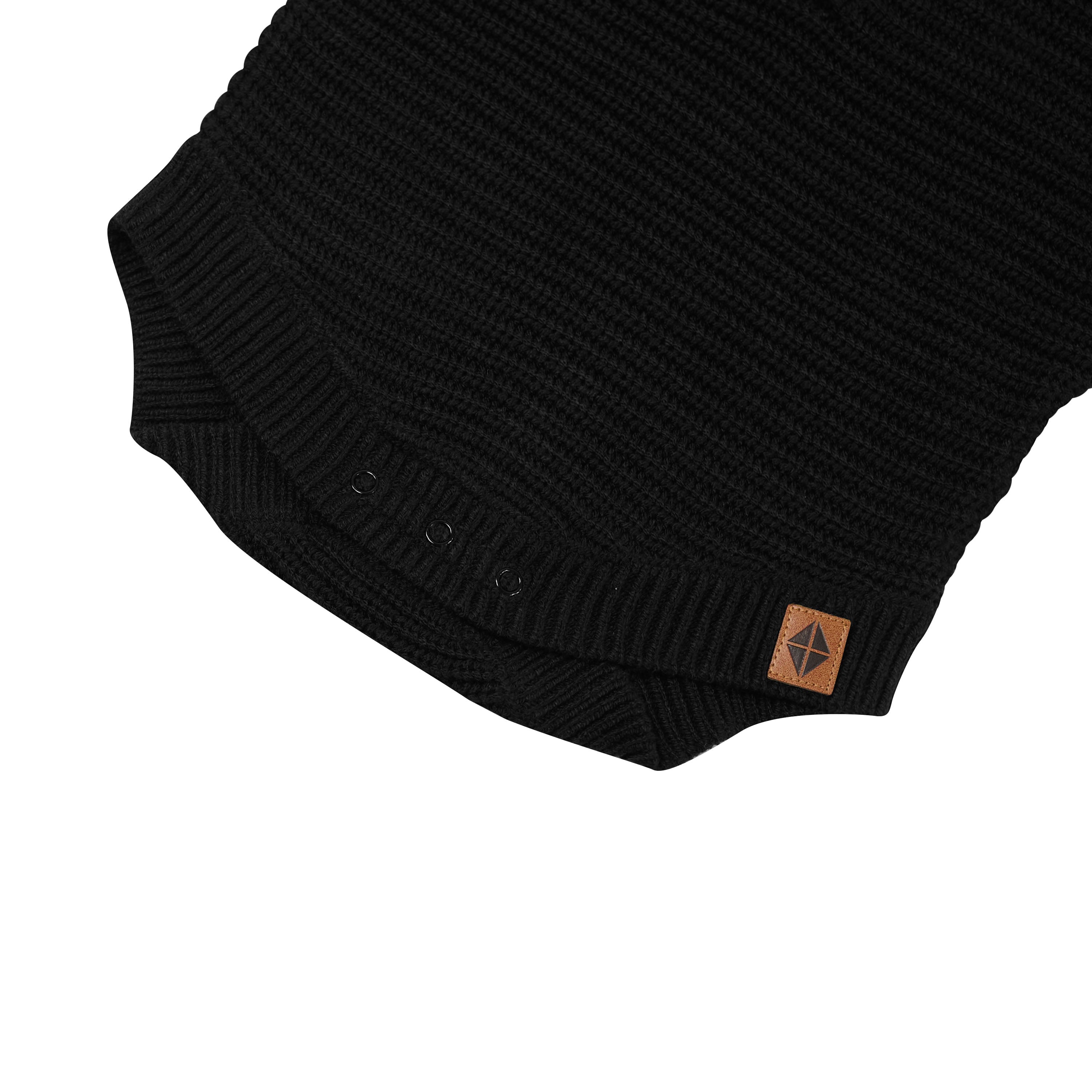Snap closures shown on the Chunky Knit Romper in Midnight with the Kyte Baby vegan leather tag visible