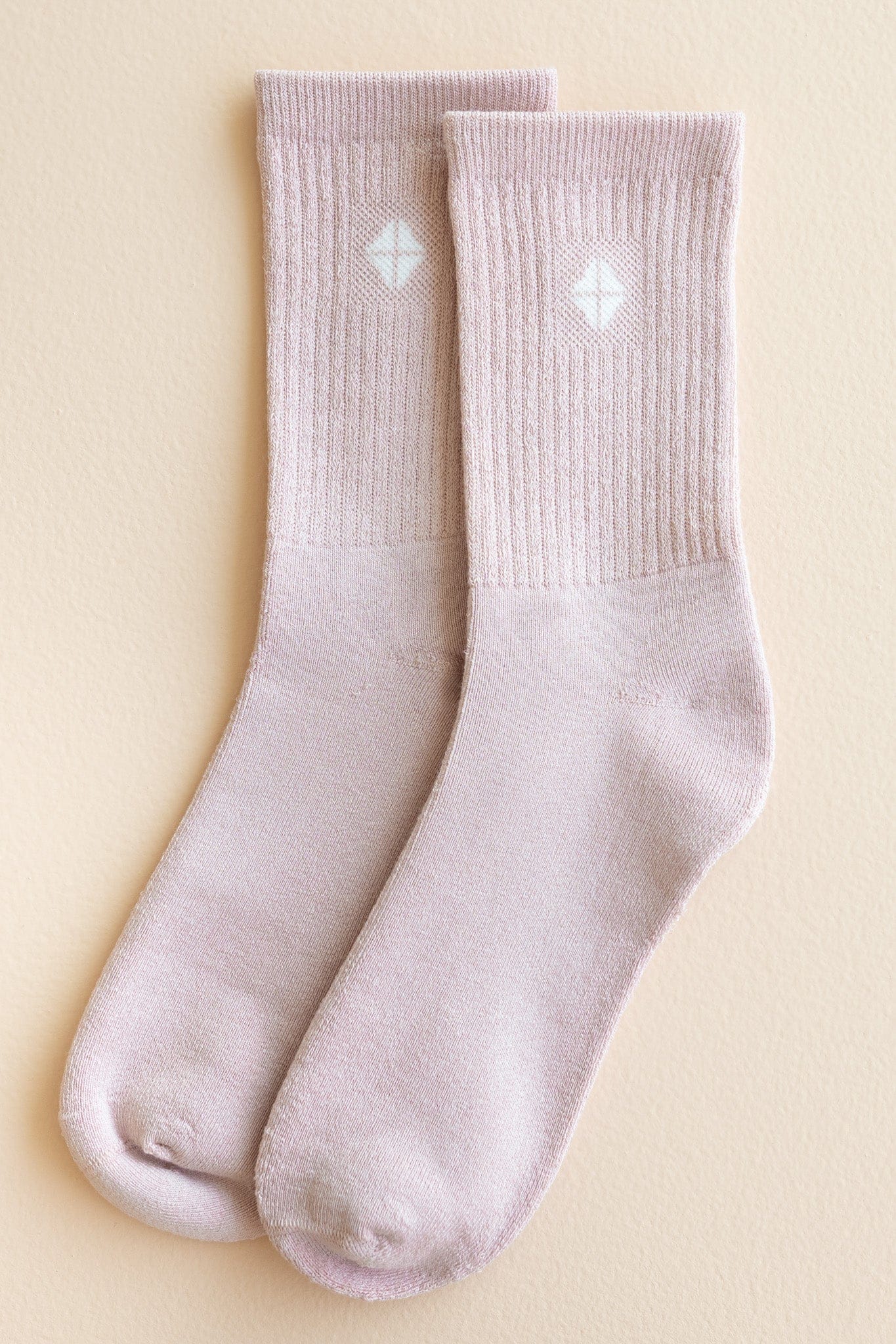 Adult Crew Socks in Blush shown out of package laying side by side on a light beige surface