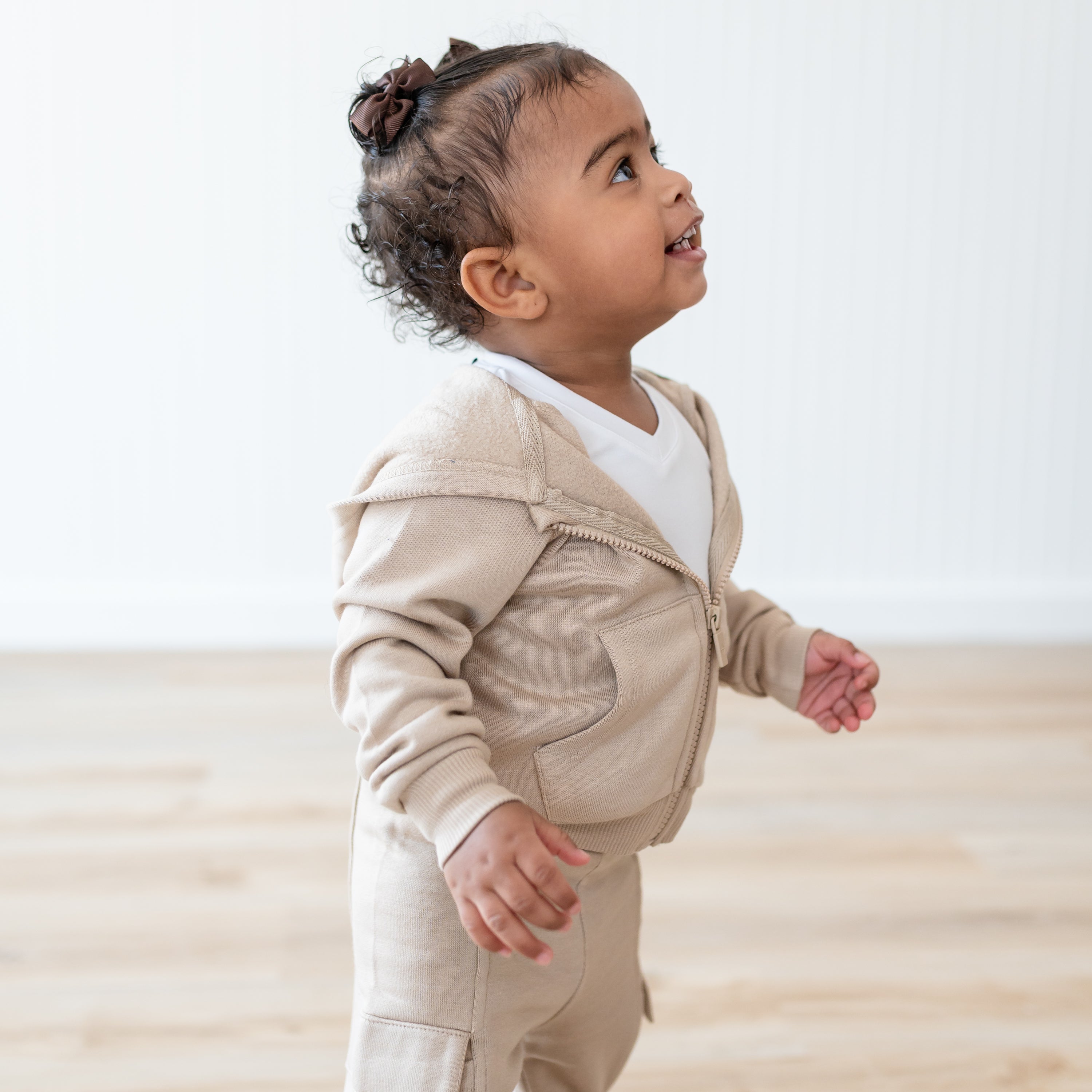 Close up of the side view of the Fleece Zip Up Hoodie in Almond shown on a young toddler