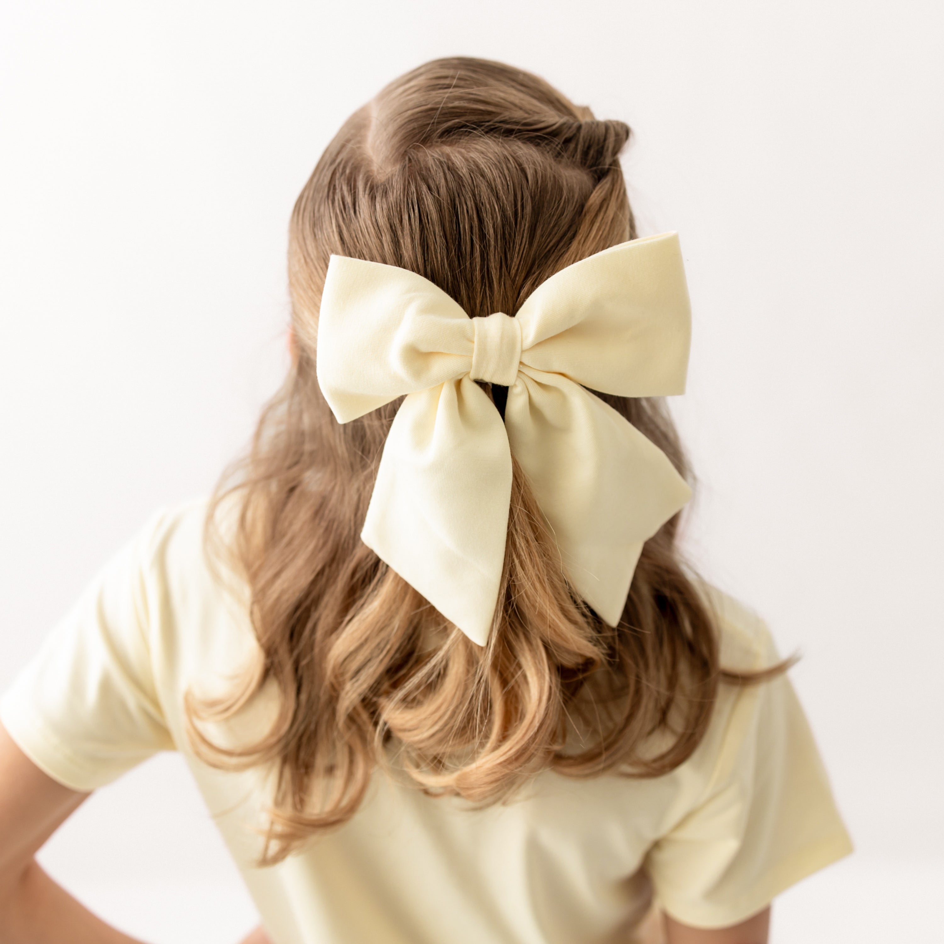 Close up of the Large Alligator Clip Bow in Chamomile shown in a young girls hair