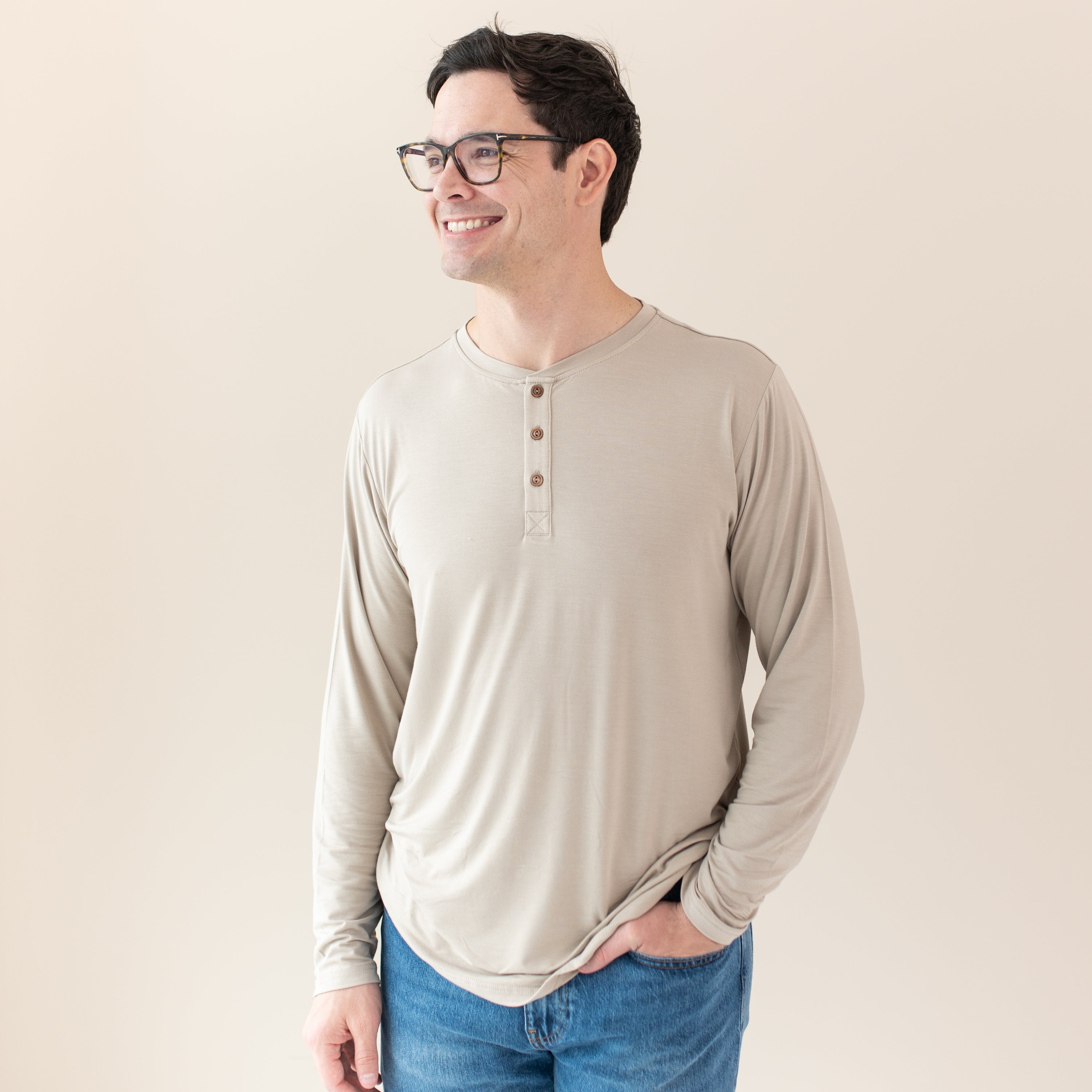 Man with glasses modeling Men's Long Sleeve Henley Top in Almond and jeans