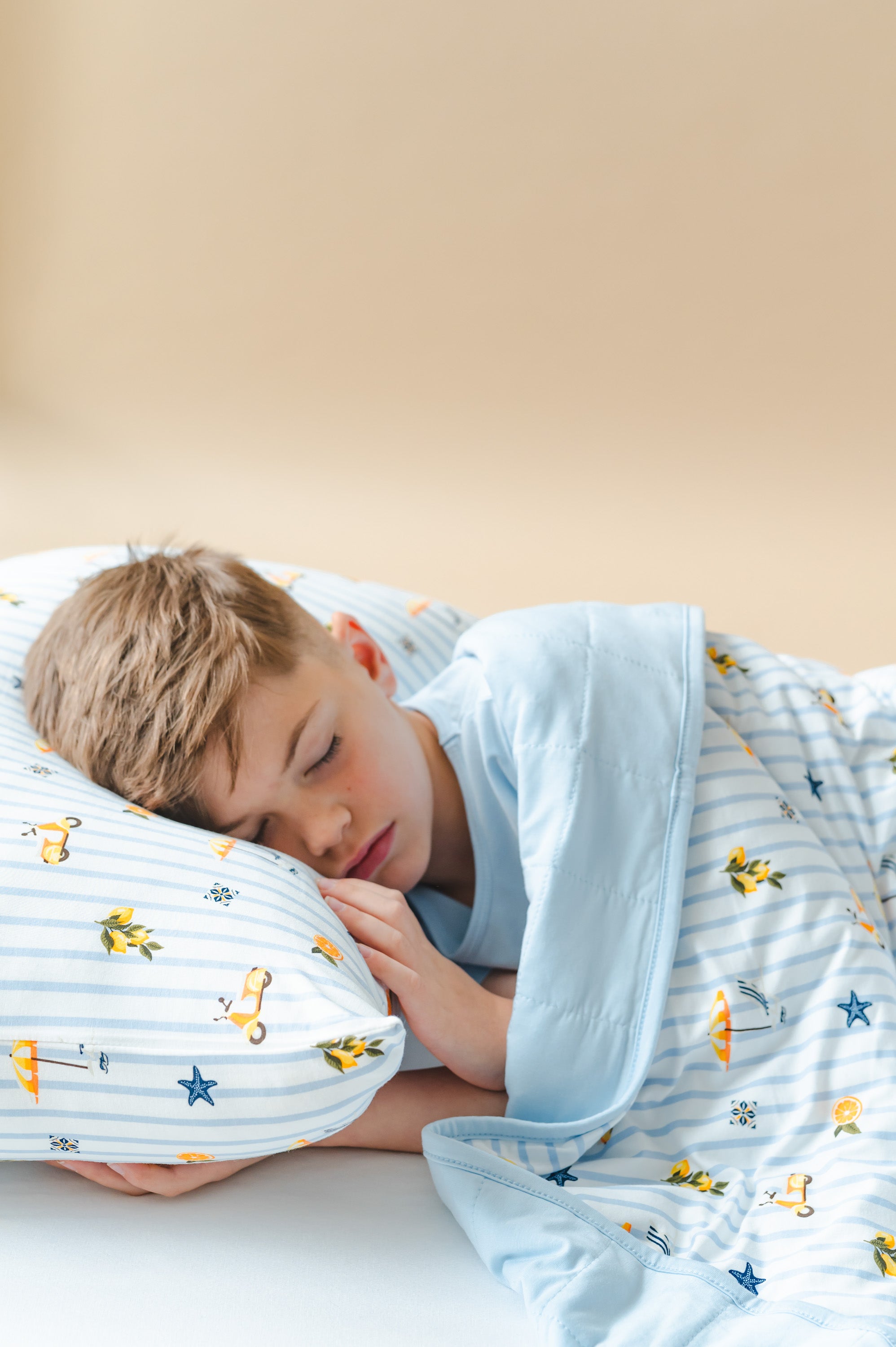Young boy laying in a bed wearing the Standard Pillowcase in Amalfi Coast